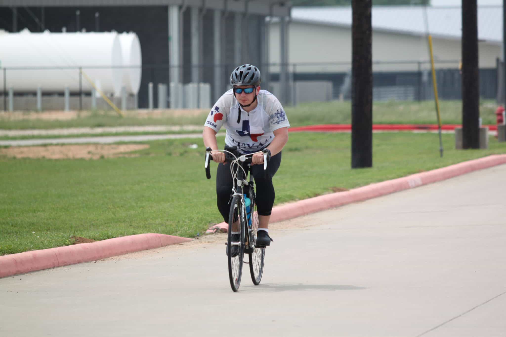 Bike rider wearing helmet and sunglasses on a cycling route.