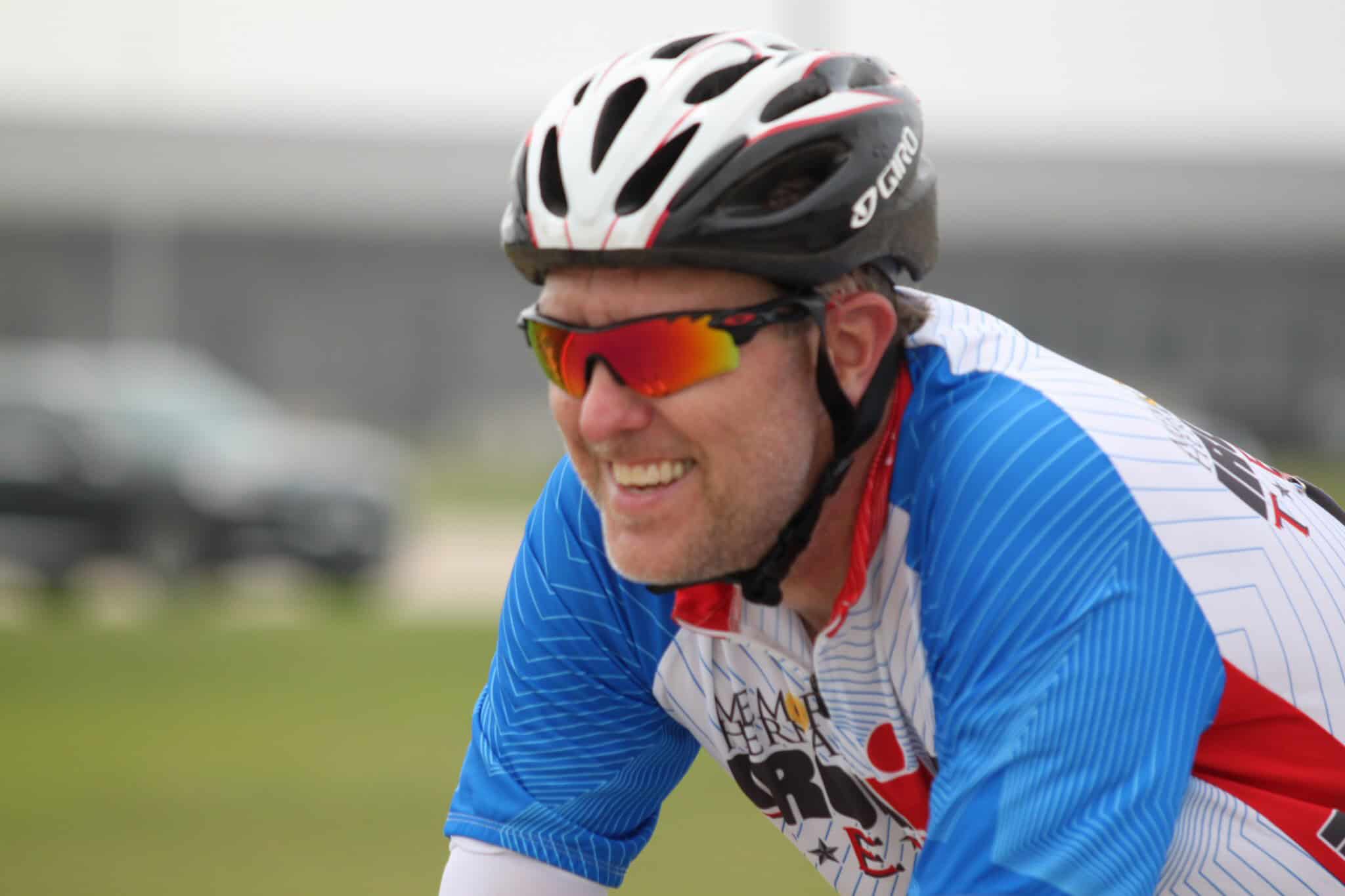 Focused cyclist wearing a helmet and sports sunglasses during a race or ride.