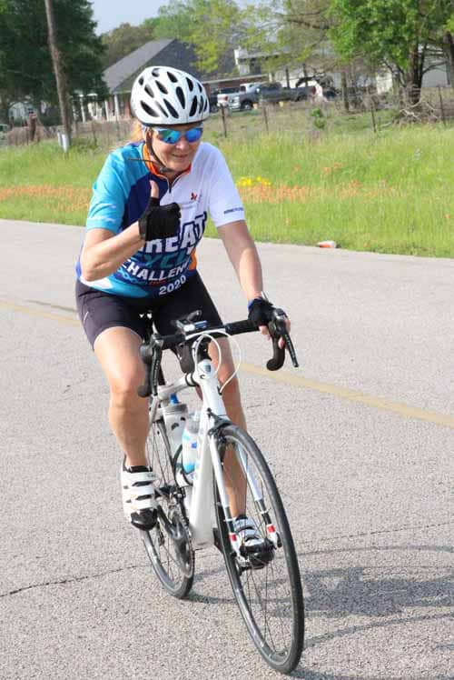 Active cyclist riding on scenic countryside road during Bluebonnet Express event.