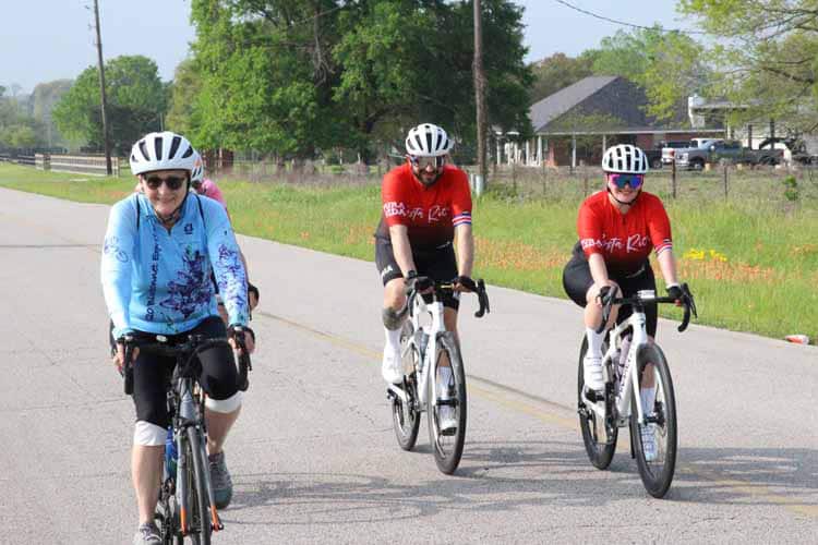 High school cyclists riding on a rural road during outdoor training session.