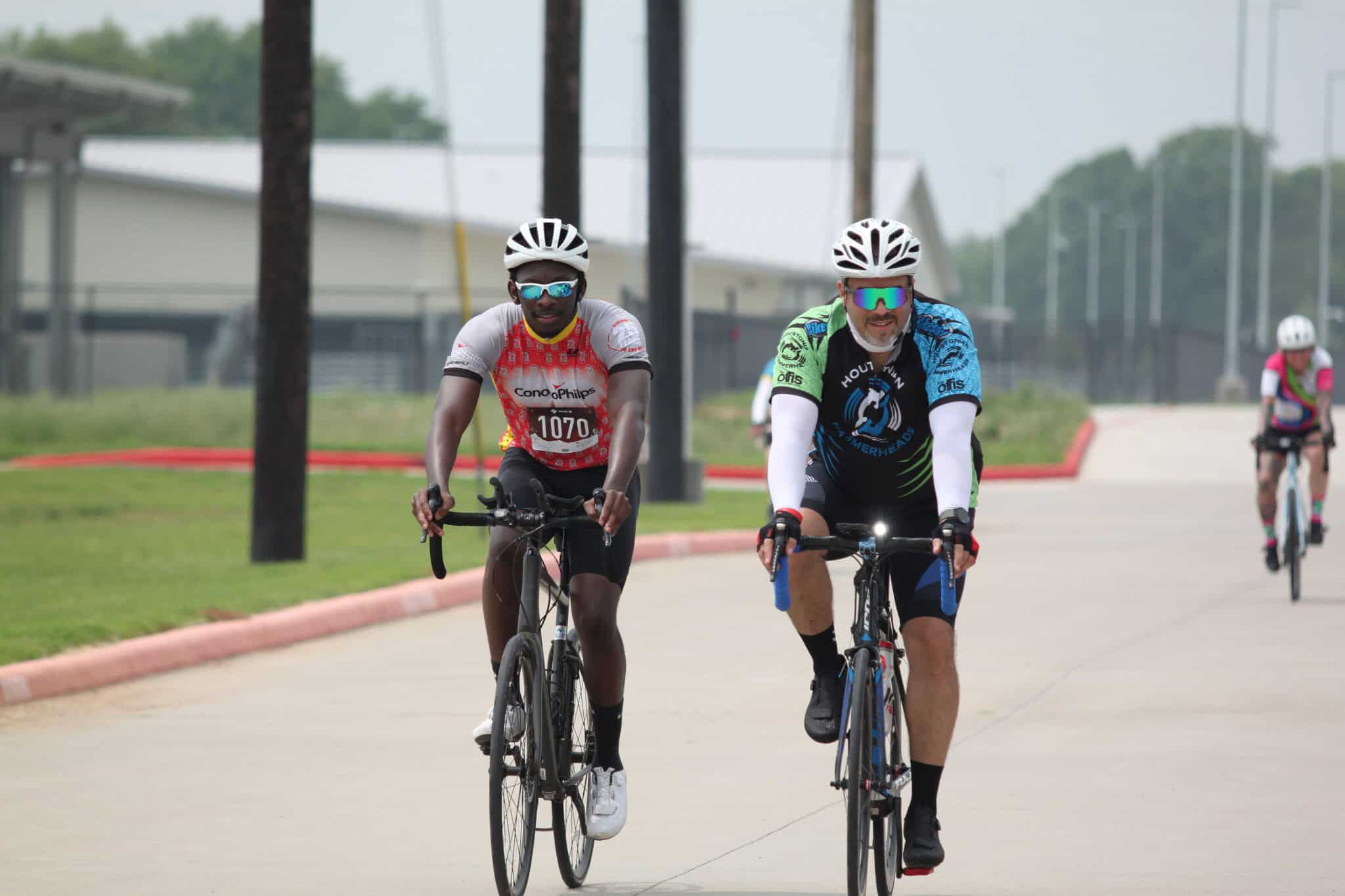 Vibrant cyclists riding on a scenic bike trail promoting Bluebonnet Express bike tours and events.