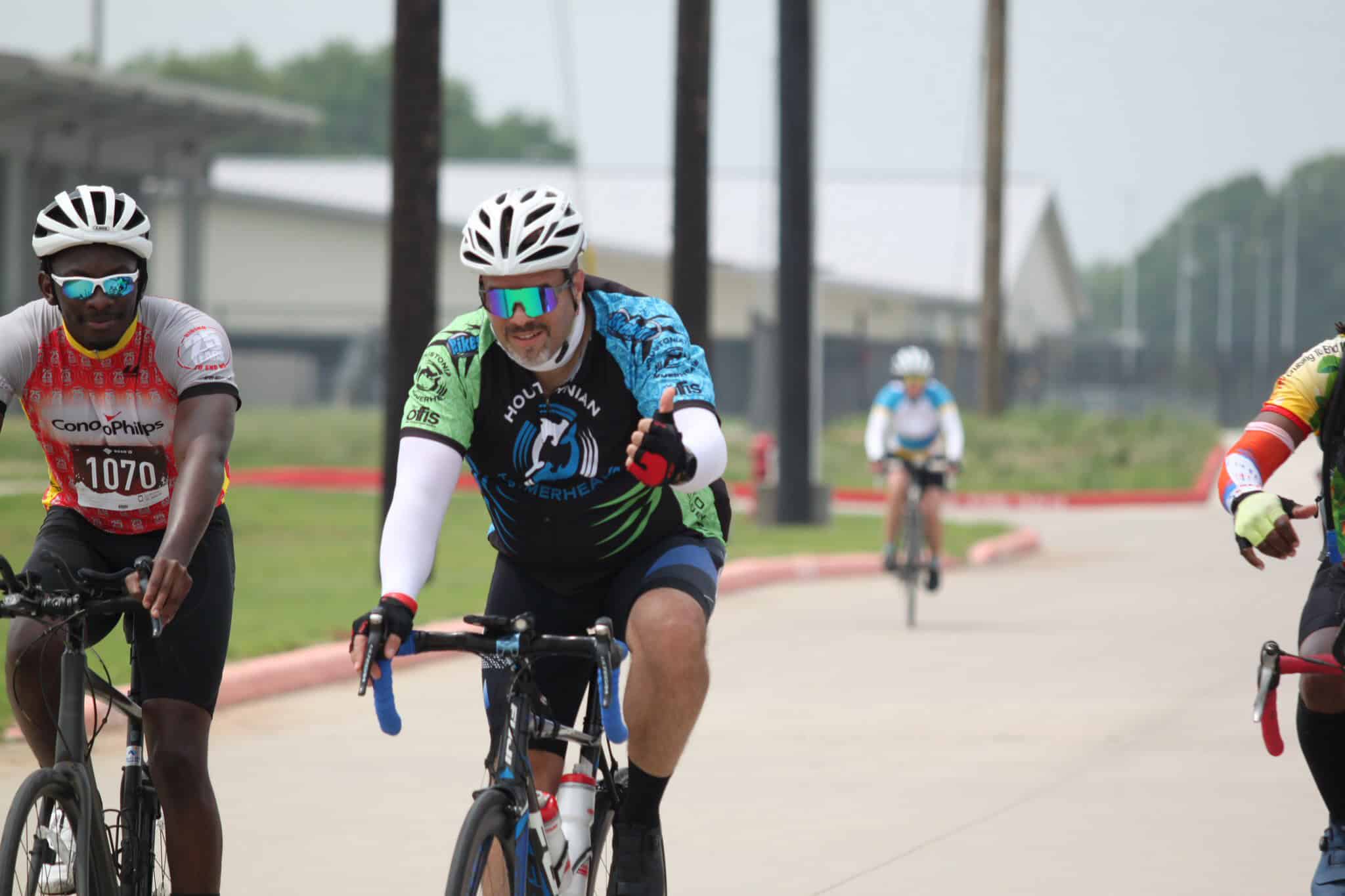 Brightly dressed cyclists racing on a sunny day for Bluebonnet Express bike event.