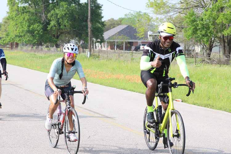 Vibrant cyclists enjoying a scenic ride along Bluebonnet Express bike trail.