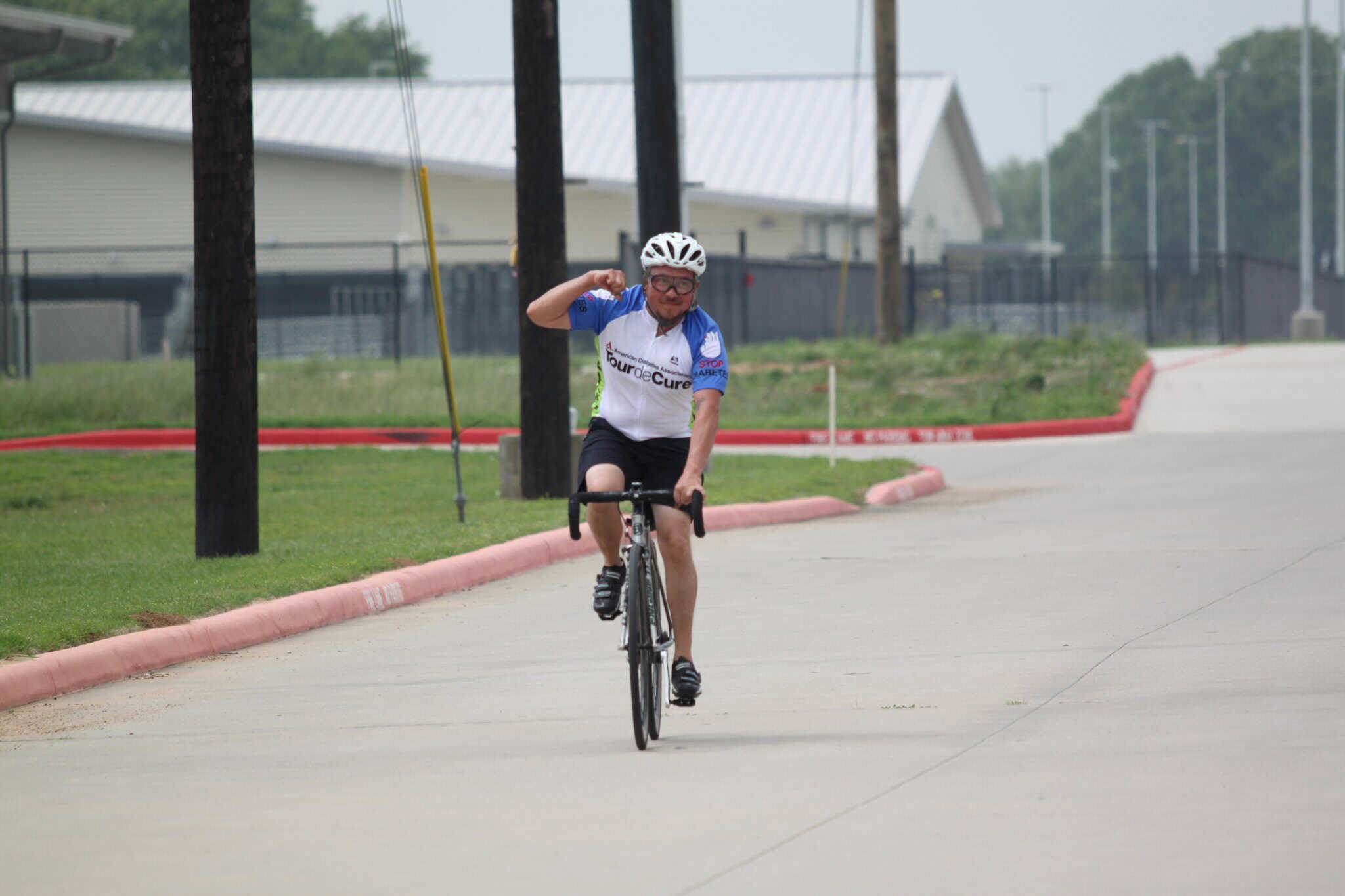 Cyclist riding on a paved road during Bluebonnet Express event, promoting cycling for charity.