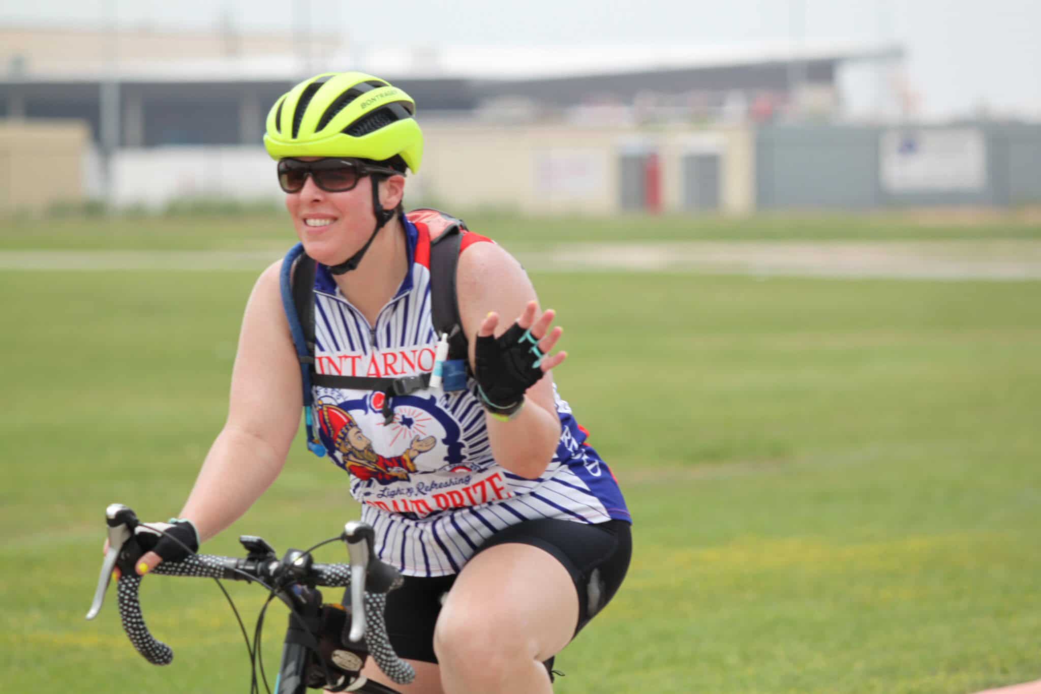 Bright yellow bike helmet, sunglasses, and athletic cycling gear in action at Bluebonnet Express event.