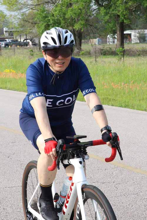 Smiling cyclist riding a road bike during Bluebonnet Express event in Texas.
