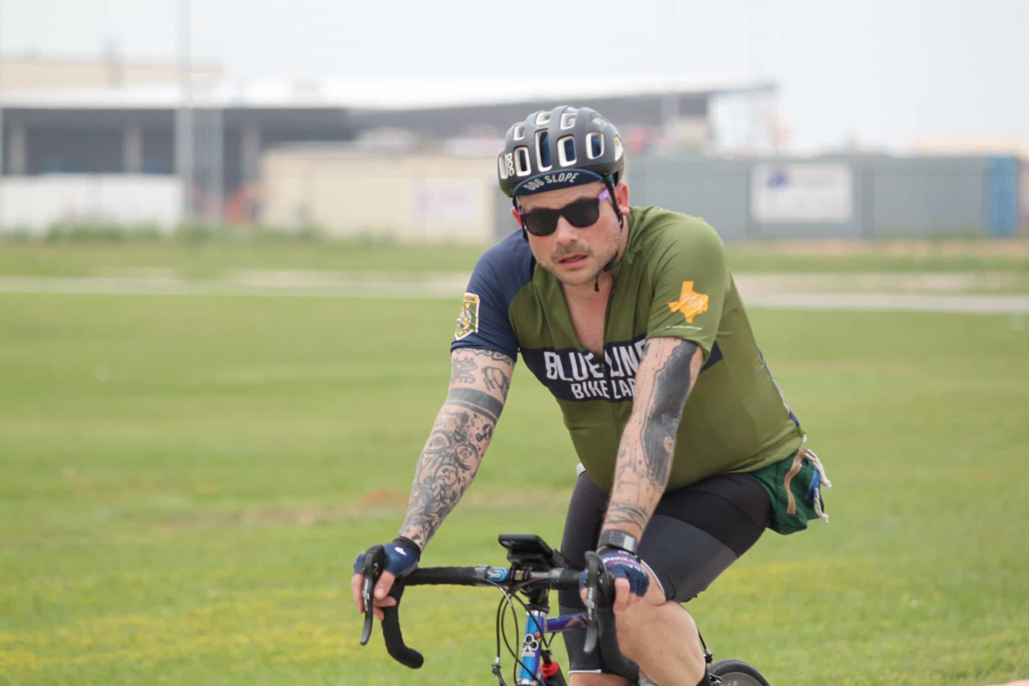 Rider on a bicycle wearing helmet and sunglasses at Bluebonnet Express bike event.