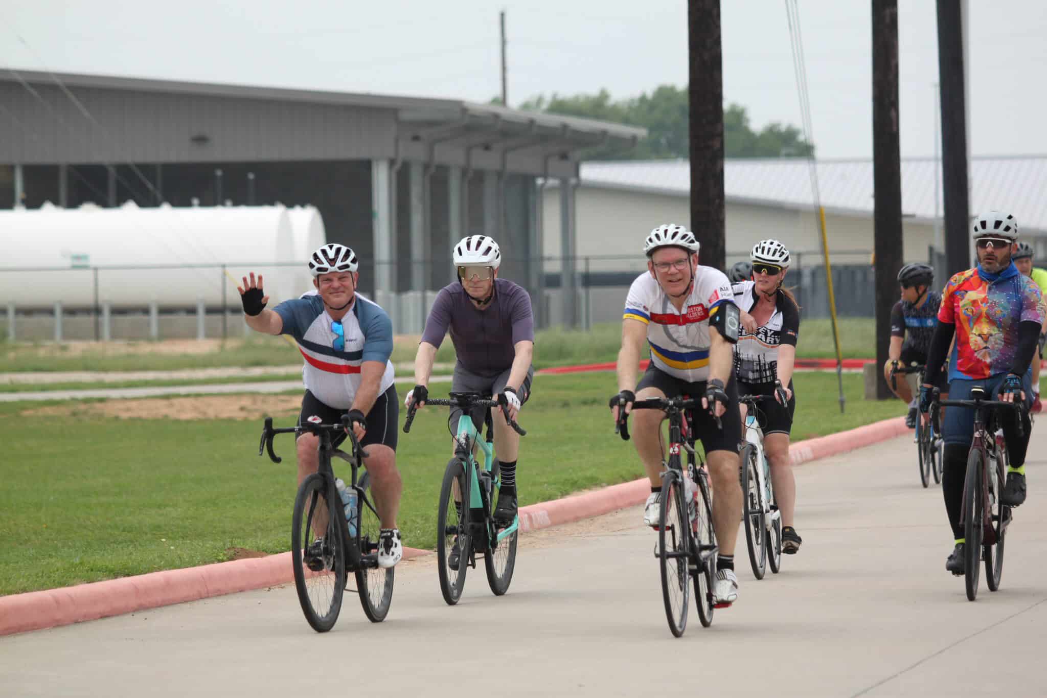 Joyful group cycling on the Bluebonnet Express, promoting community and outdoor fitness.