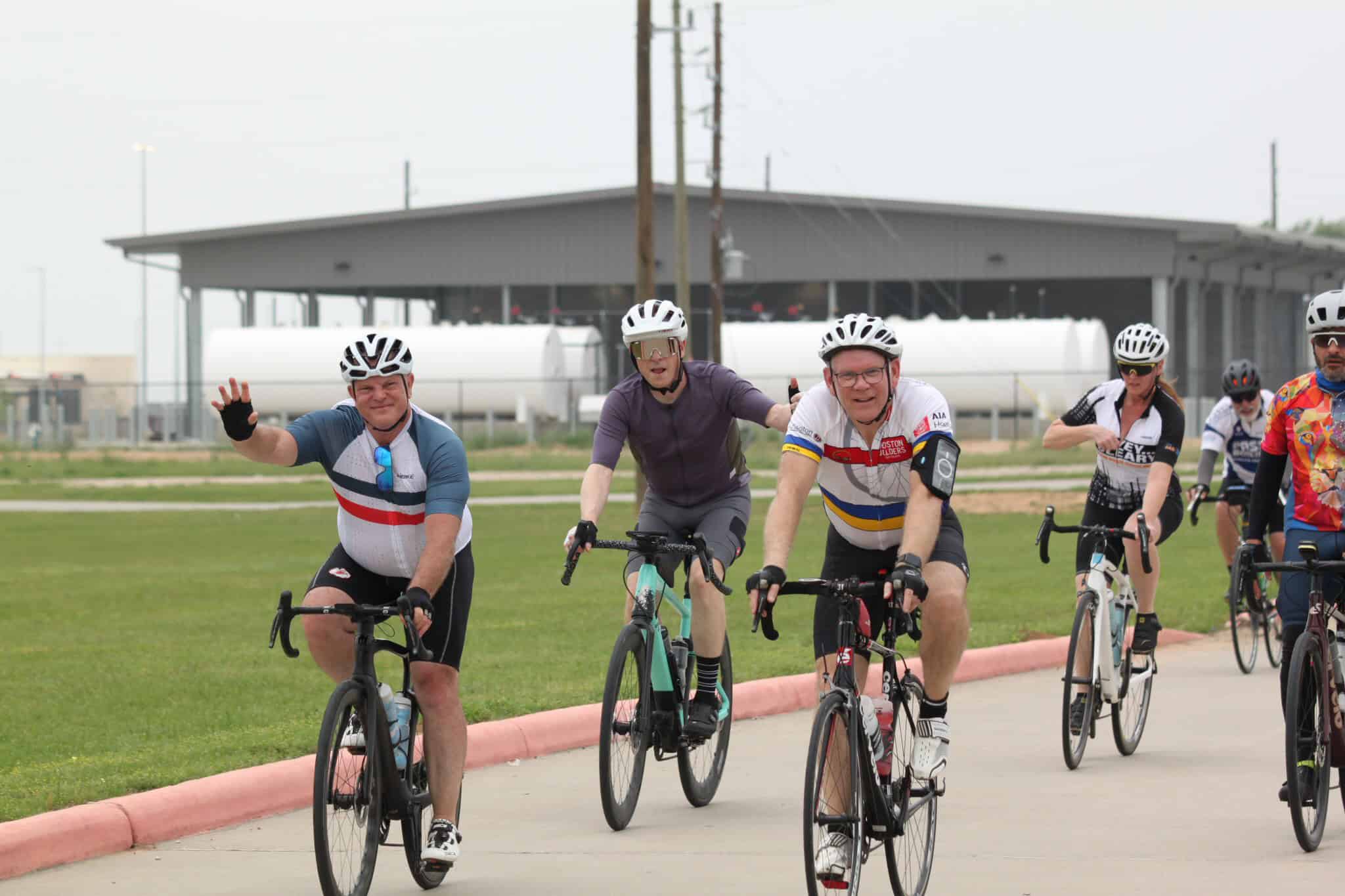 Bright group of cyclists enjoying a bike ride with Bluebonnet Express logo, celebrating cycling event.