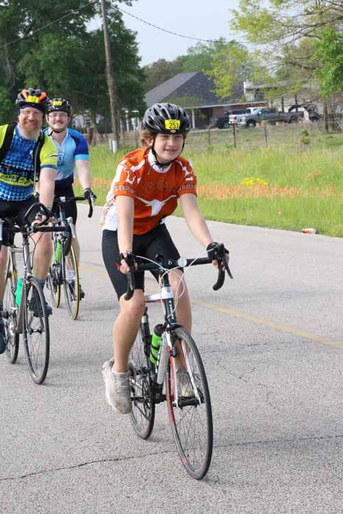 1. Group of cyclists riding on a scenic road during Bluebonnet Express event.