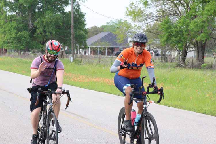Brightly dressed cyclists enjoying a scenic ride on Bluebonnet Express bike trail in Texas.
