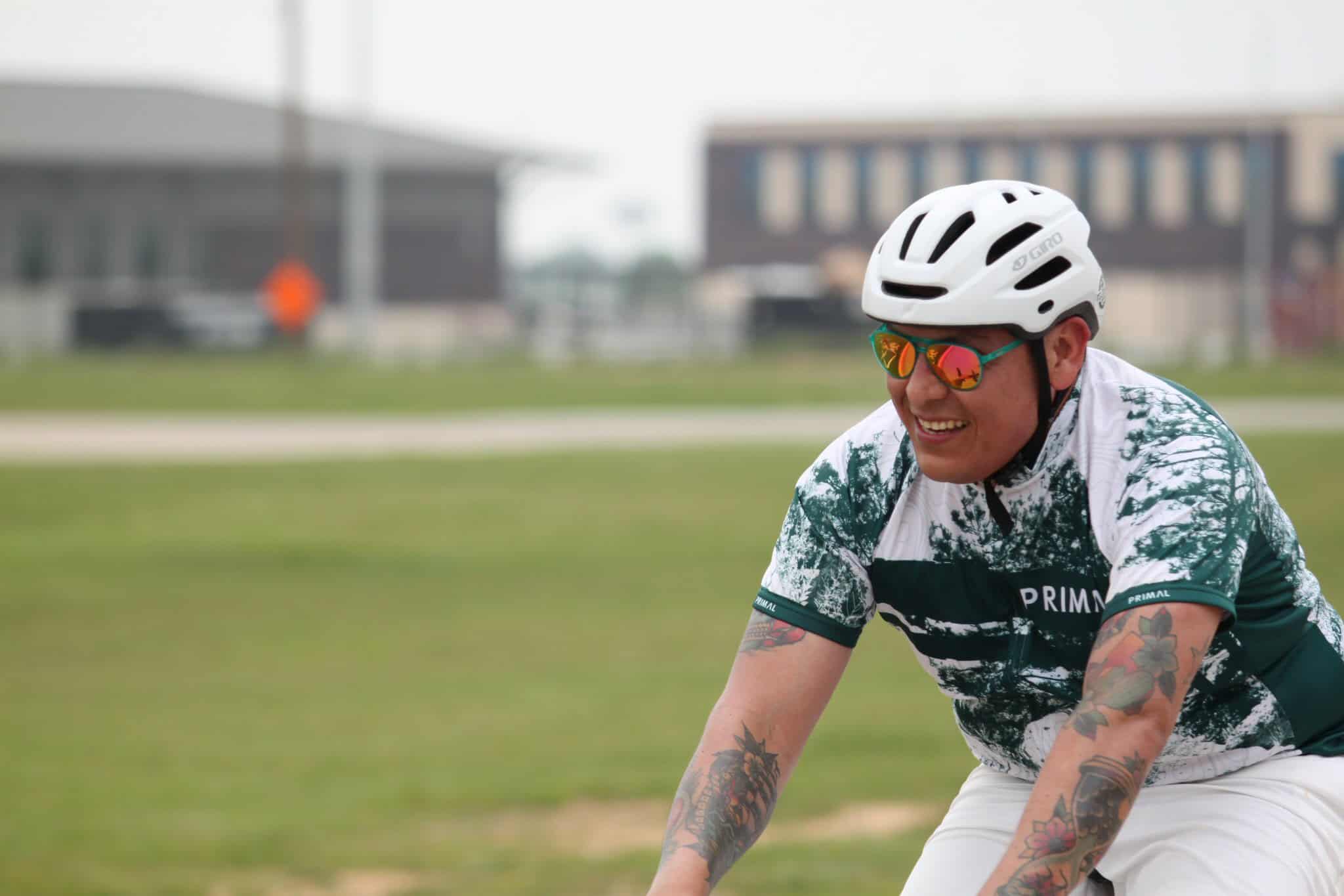 Bright cyclist wearing helmet and reflective sunglasses during outdoor ride, promoting Bluebonnet Express bike service.
