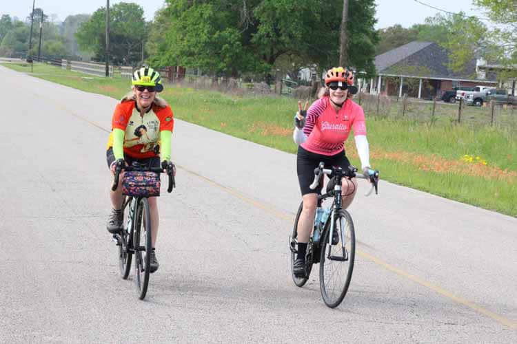 Brightly dressed cyclists enjoying a ride on a scenic country road during the Bluebonnet Express event.