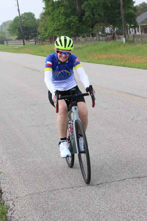Bright female cyclist enjoying ride on a suburban street in adventure gear.