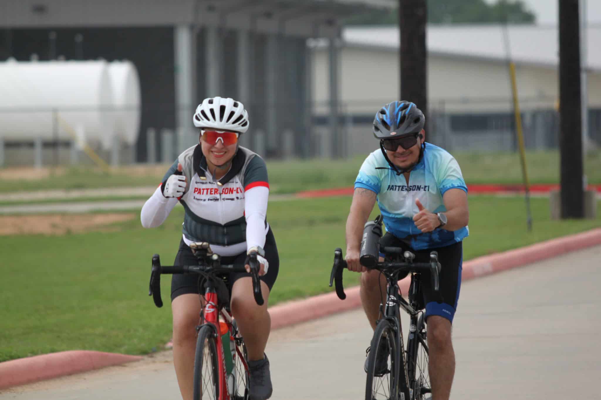 Helmeted cyclists smiling during a ride, promoting safety and fitness with Bluebonnet Express bike service.