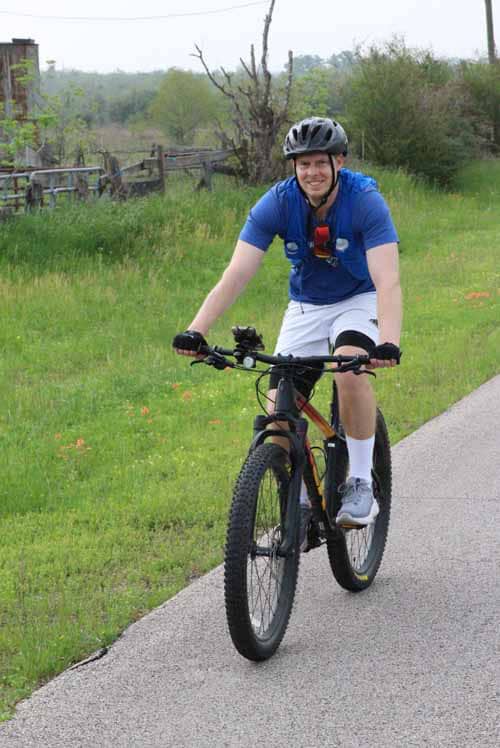 Young man riding mountain bike on scenic trail, enjoying outdoor cycling adventure.
