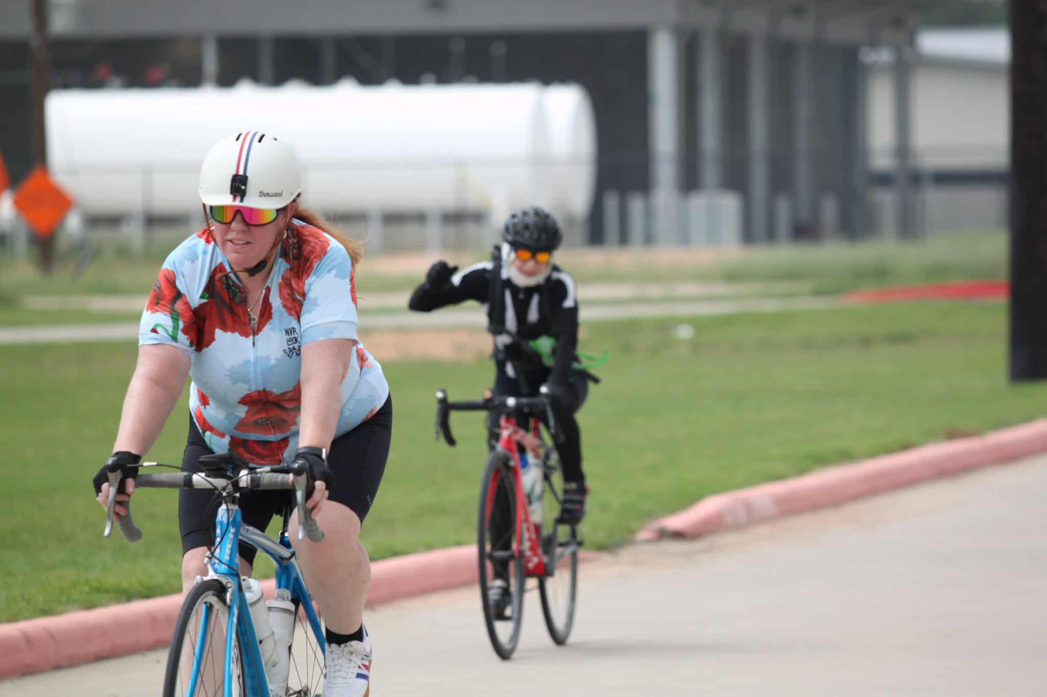 Vibrant female cyclists riding on a park trail during daytime for Bluebonnet Express event.