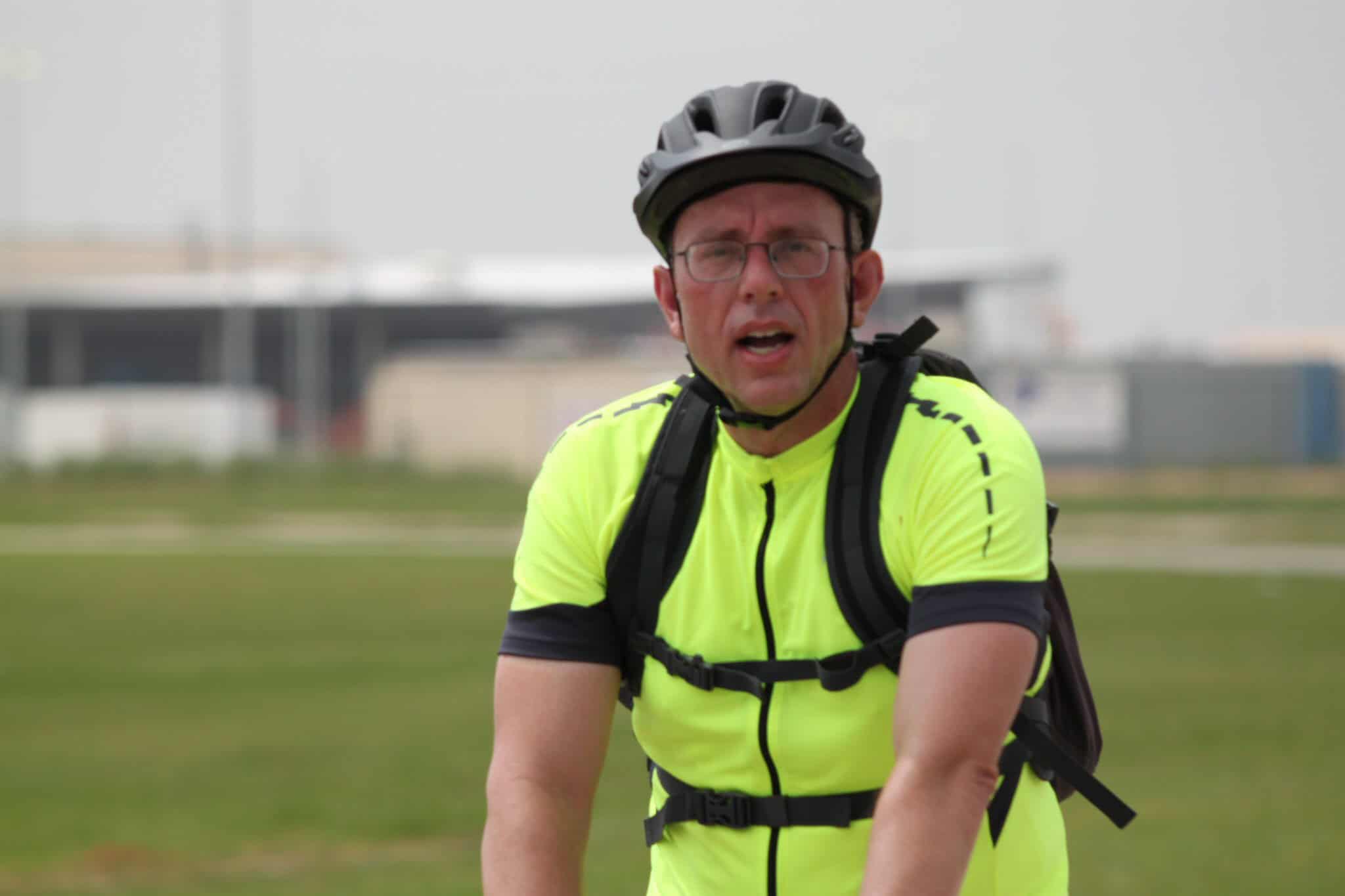 Rider wearing a helmet and neon cycling jersey outdoors, promoting Bluebonnet Express bike services.