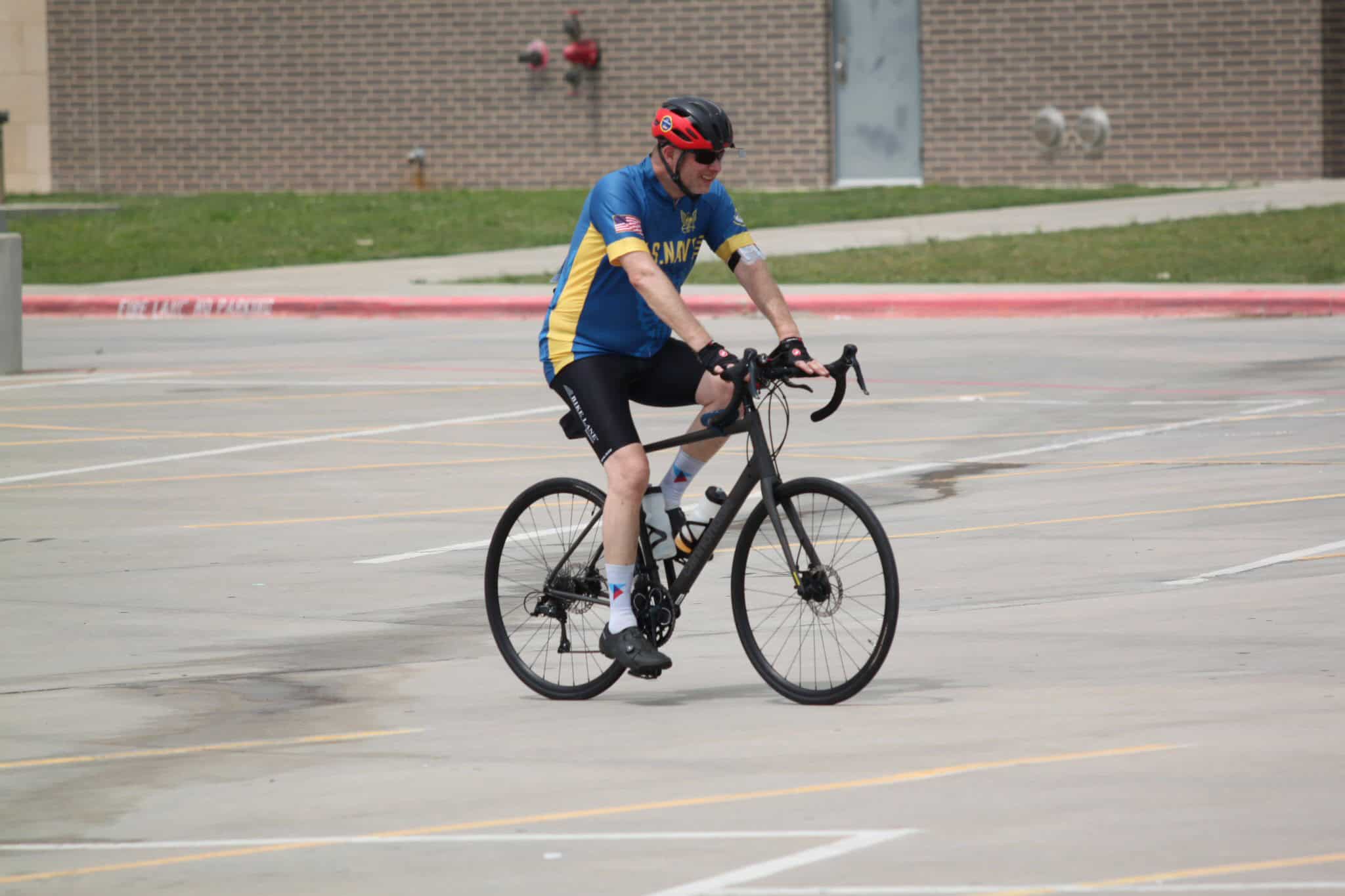 Bike riding in parking lot with Bluebonnet Express cyclist, outdoor activity, Bike ride, fitness, recreation, cycling event.