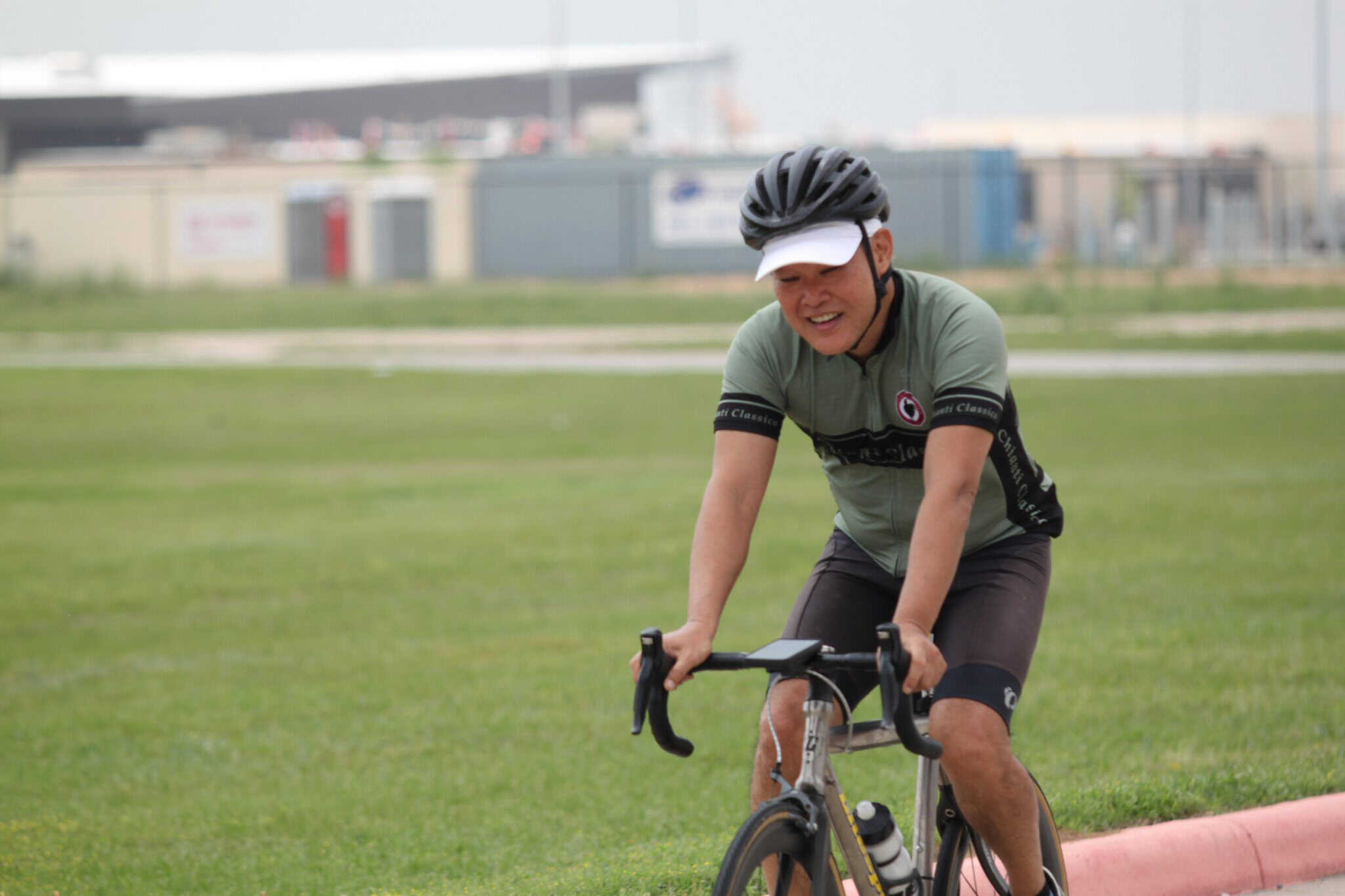 1. Male cyclist smiling riding a bike during Bluebonnet Express event.