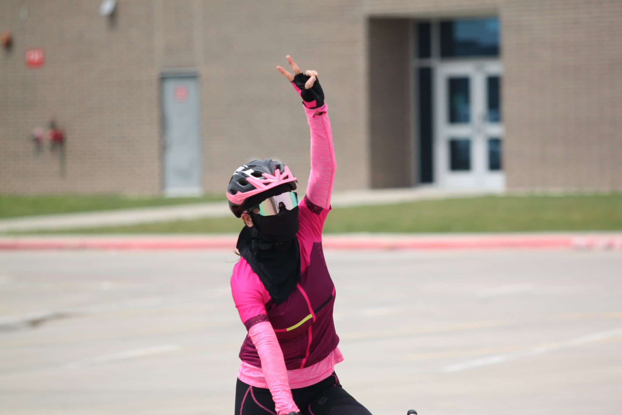 Bright pink cycling jersey, helmet, and sunglasses at Bluebonnet Express event.