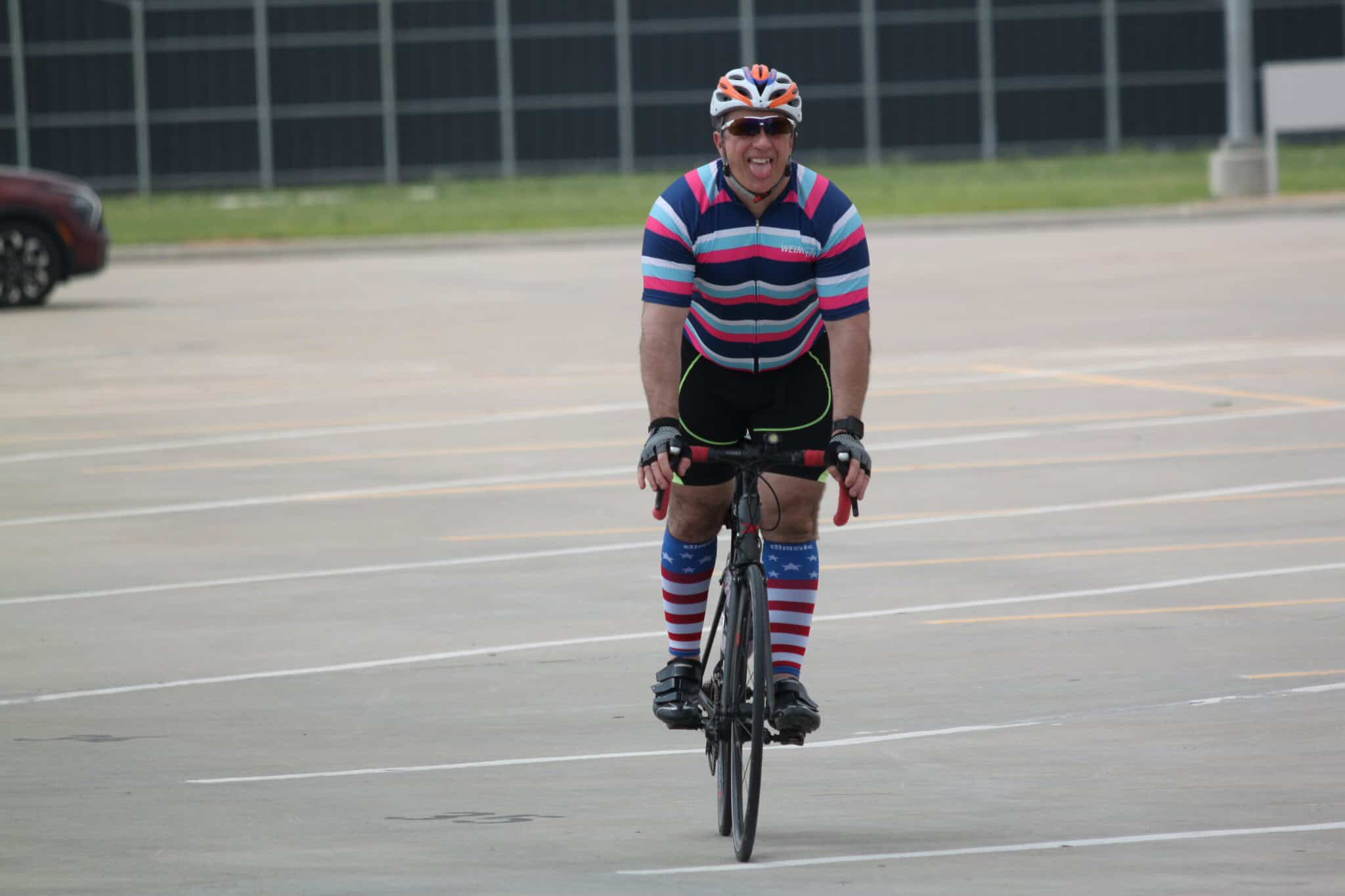Colorful cyclist enjoying a ride on the Bluebonnet Express bike trail in a parking lot.