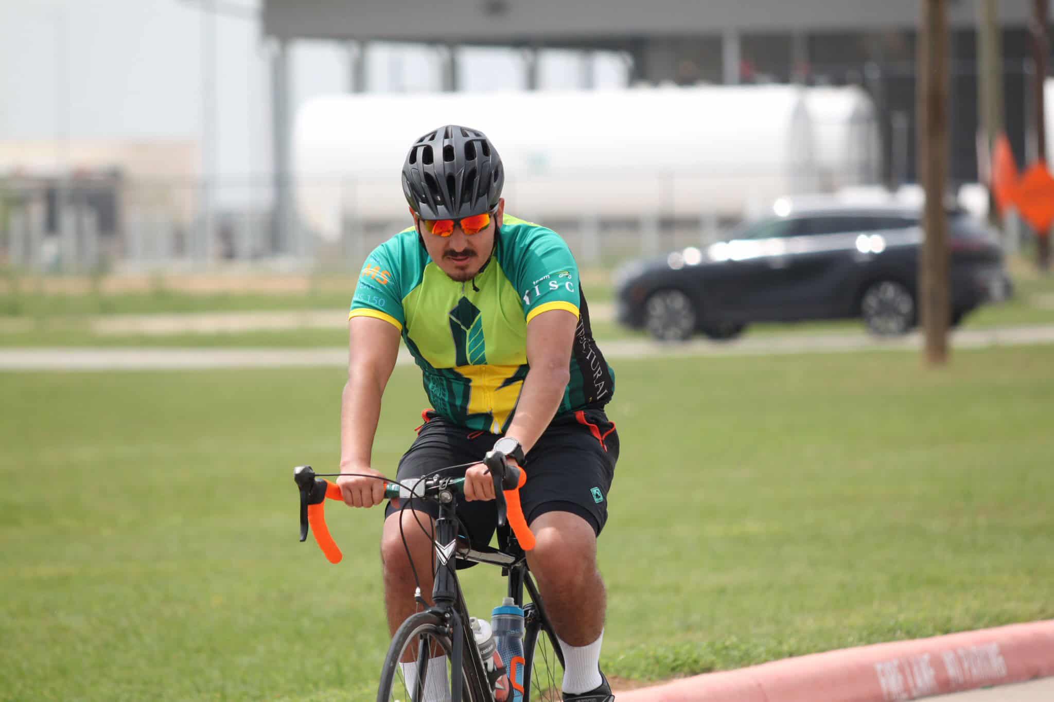 Vibrant cyclist riding outdoors on a sunny day, promoting Bluebonnet Express bike services.