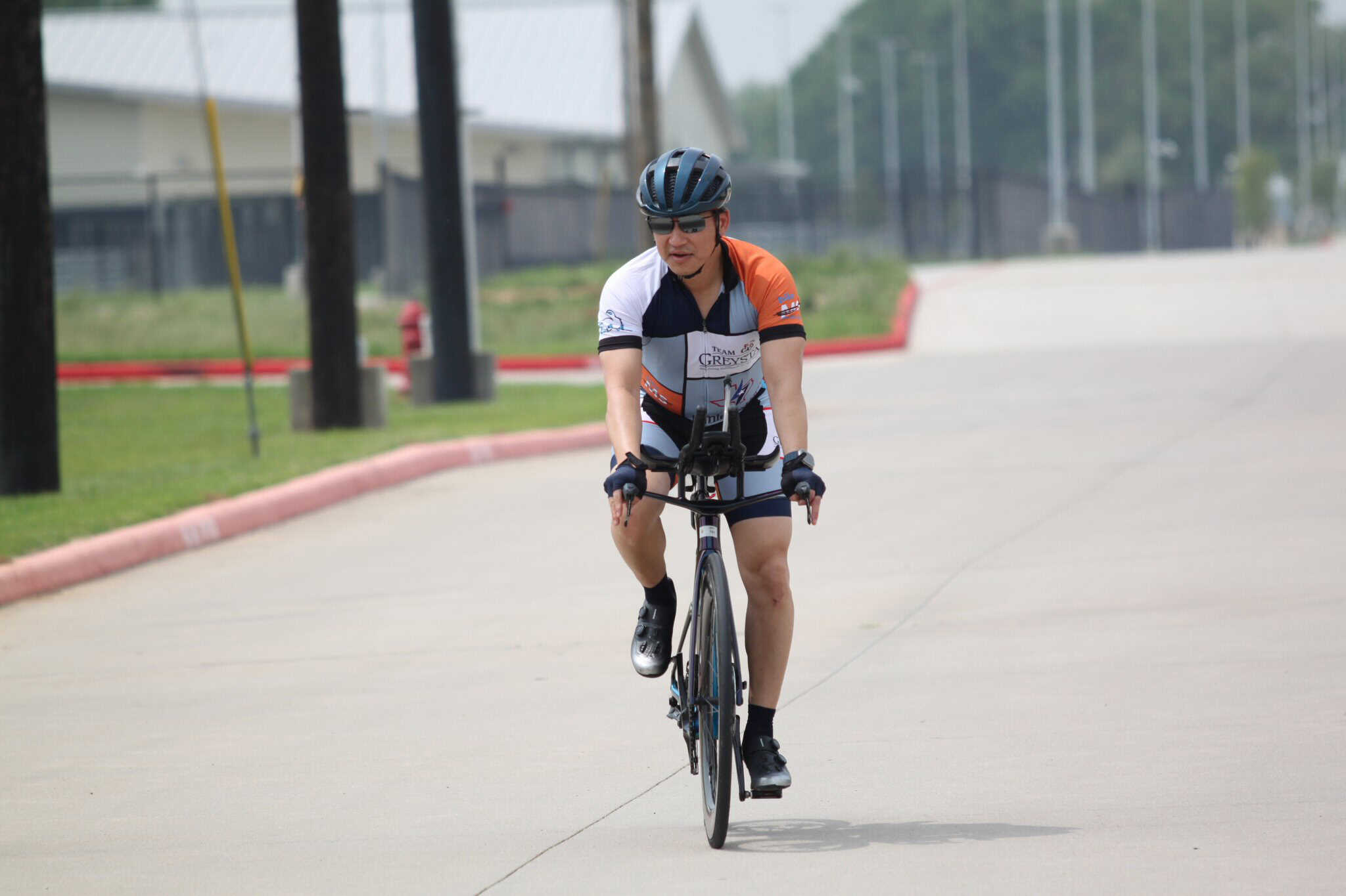 A cyclist riding a bike outdoors with a helmet and sportswear, promoting eco-friendly transportation.