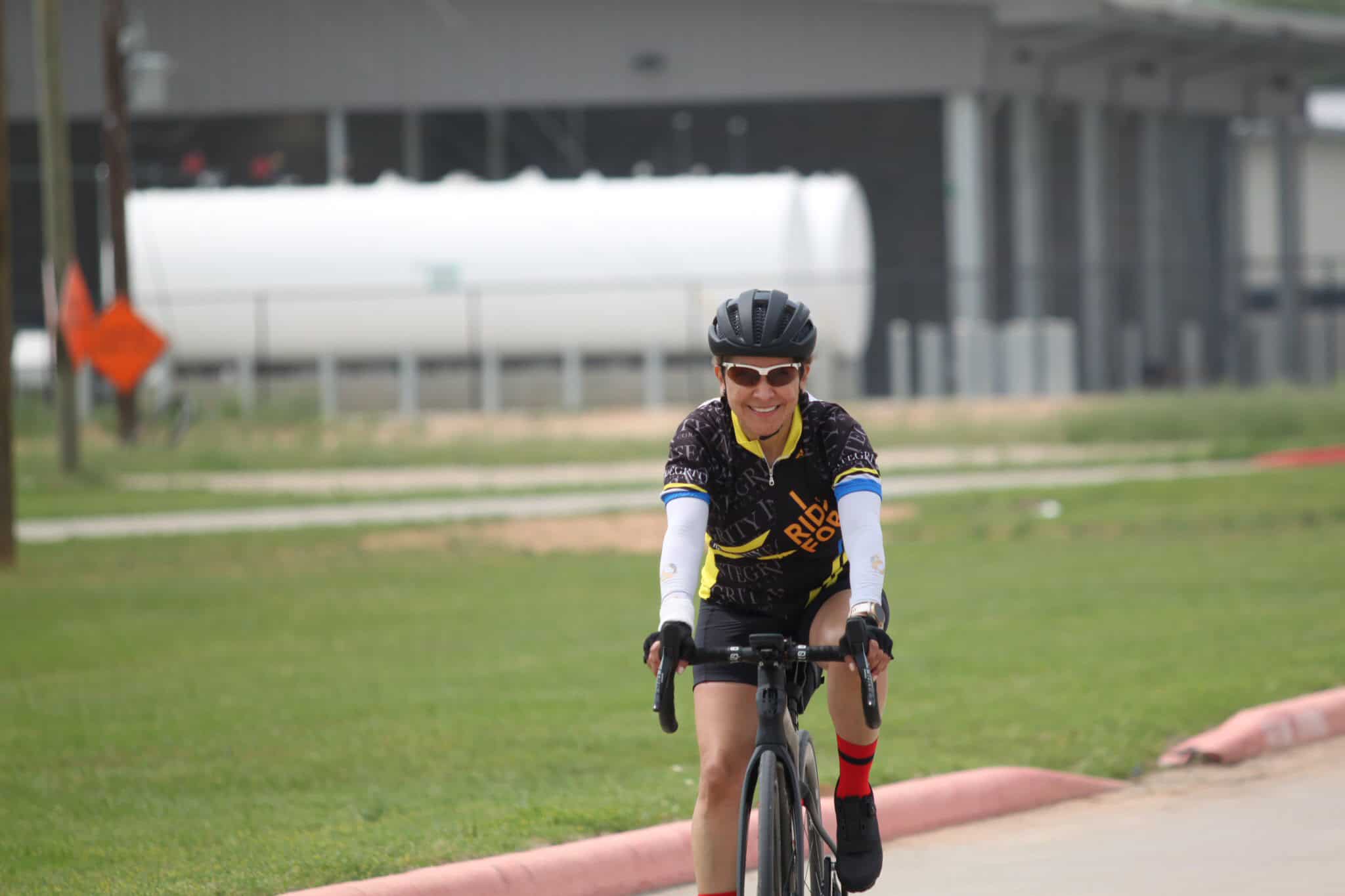 Bright smiling cyclist riding a bike during Bluebonnet Express event in Texas, promoting community outdoor activities.
