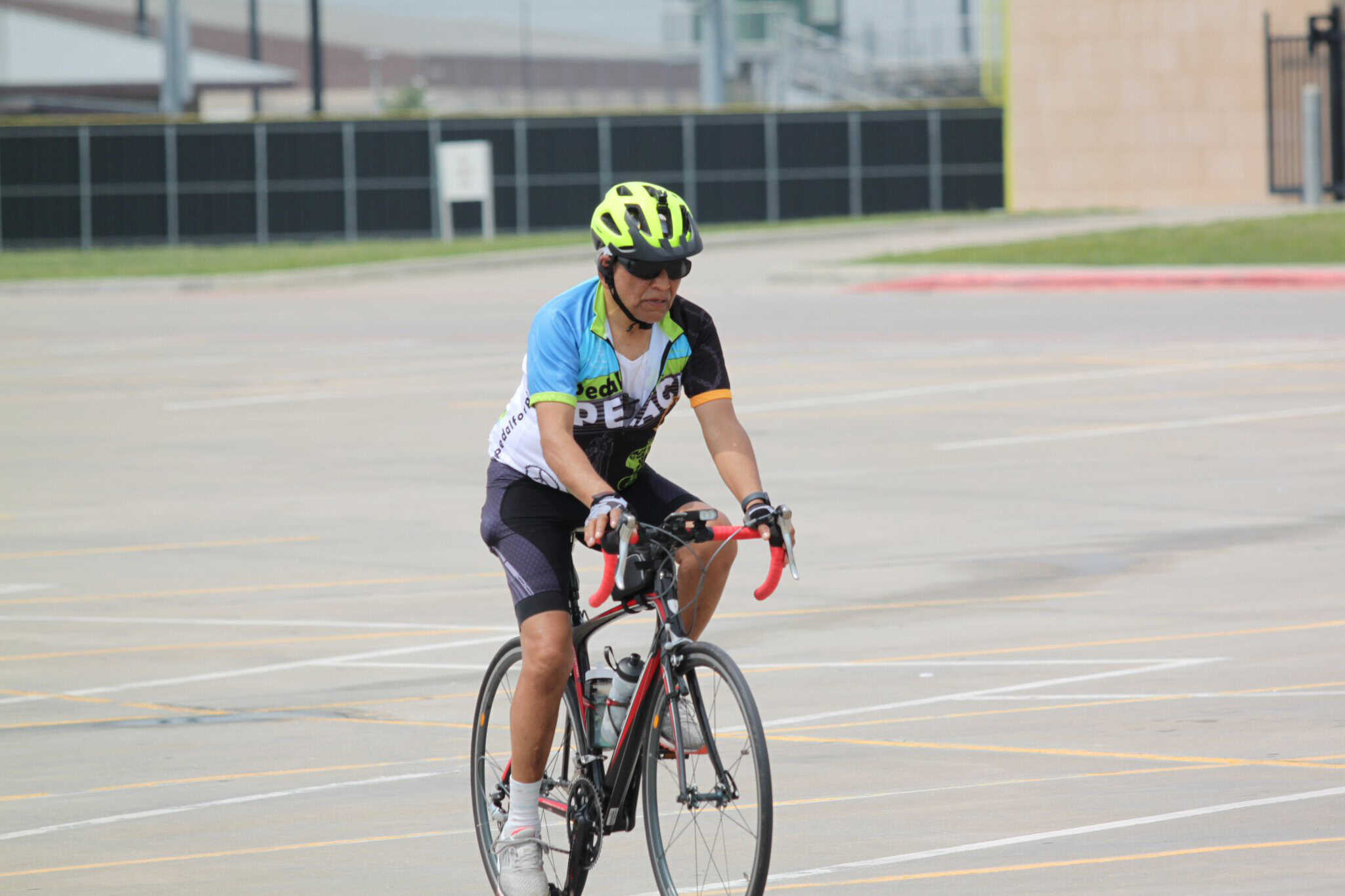 Adult male cyclist riding electric bike on pavement during daytime.
