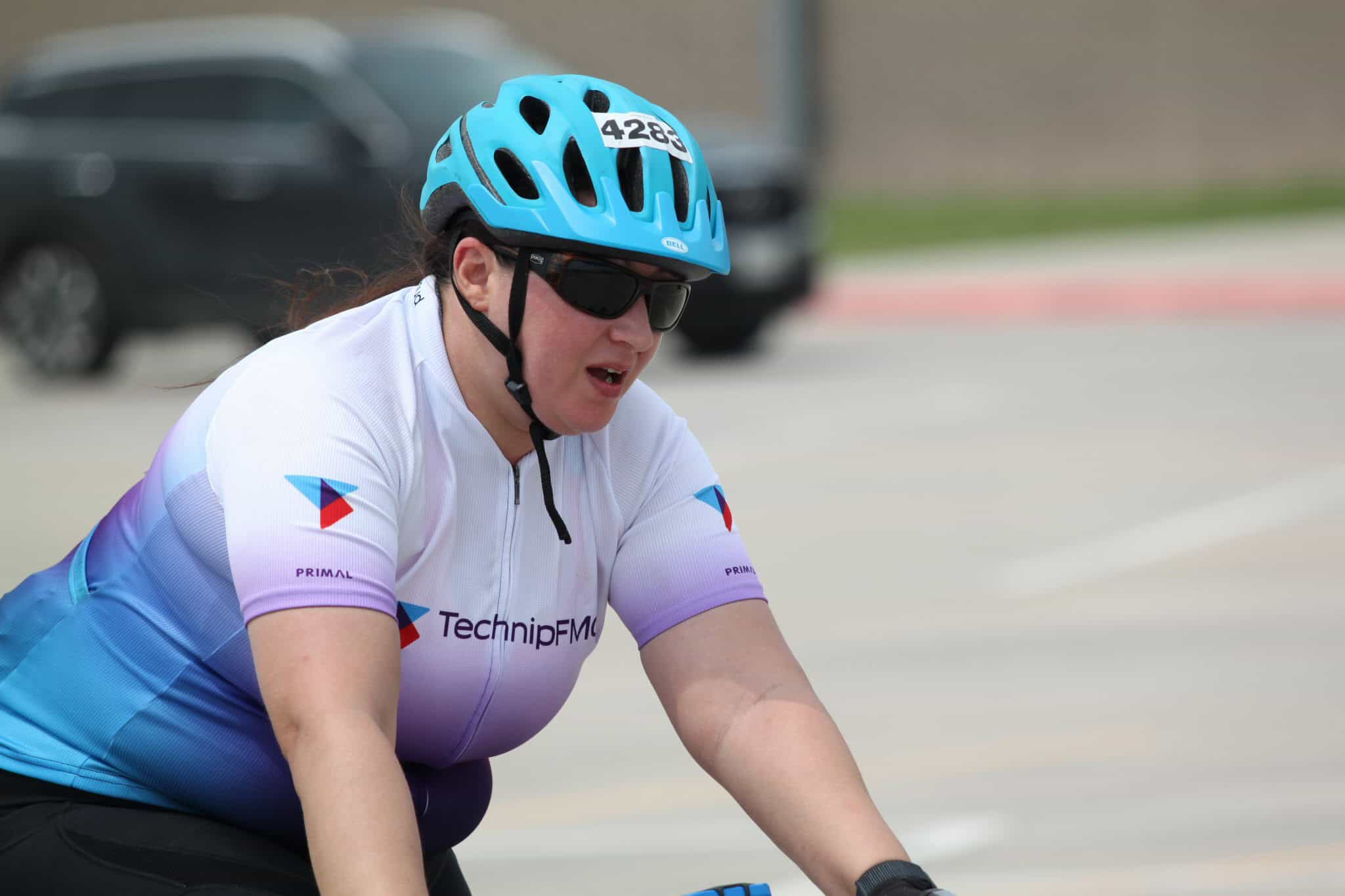 Bike racer wearing Bluebonnet Express cycling jersey and helmet on the road.