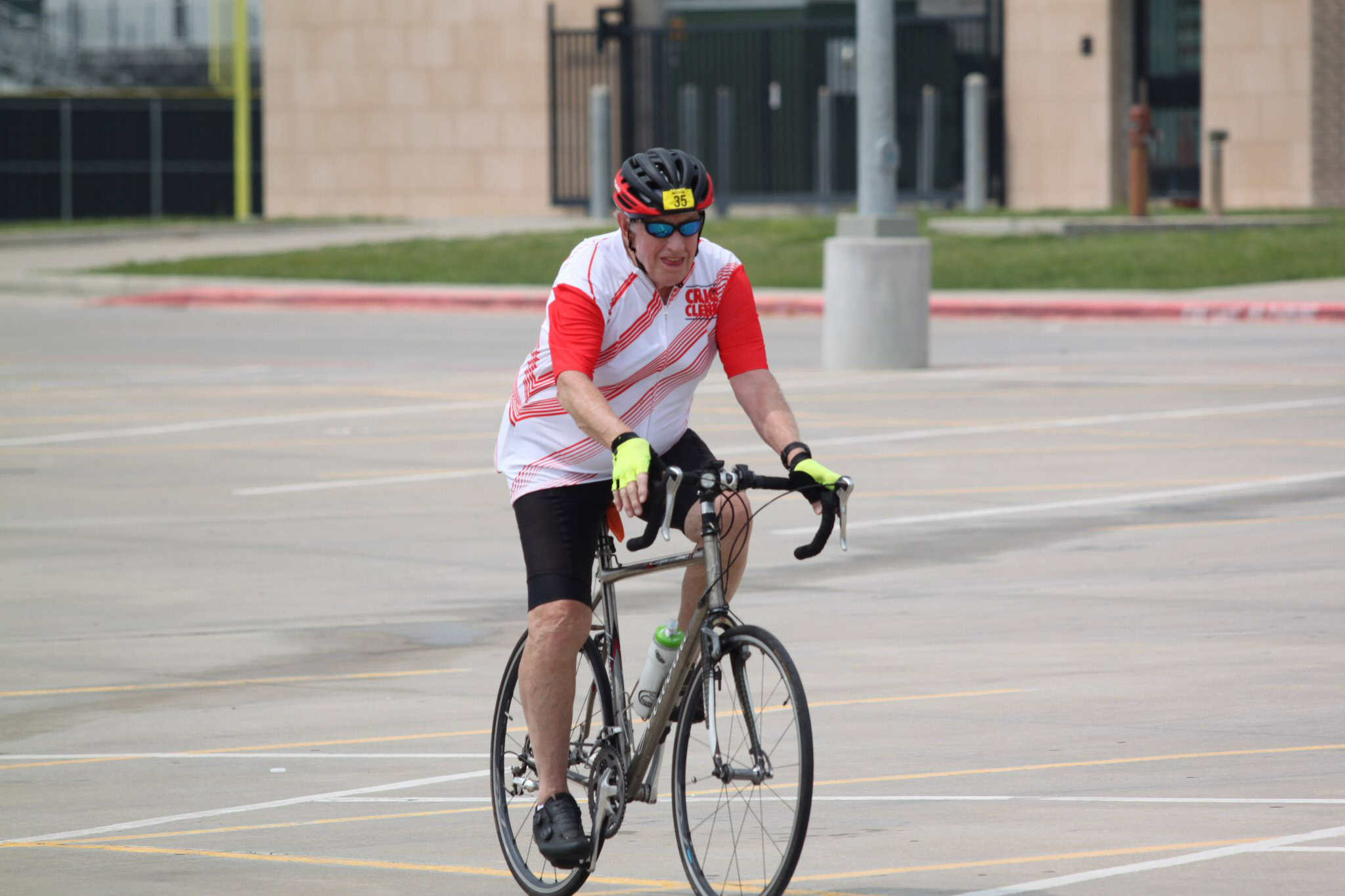Active senior man cycling on a city street with road bike, promoting health and outdoor activity.
