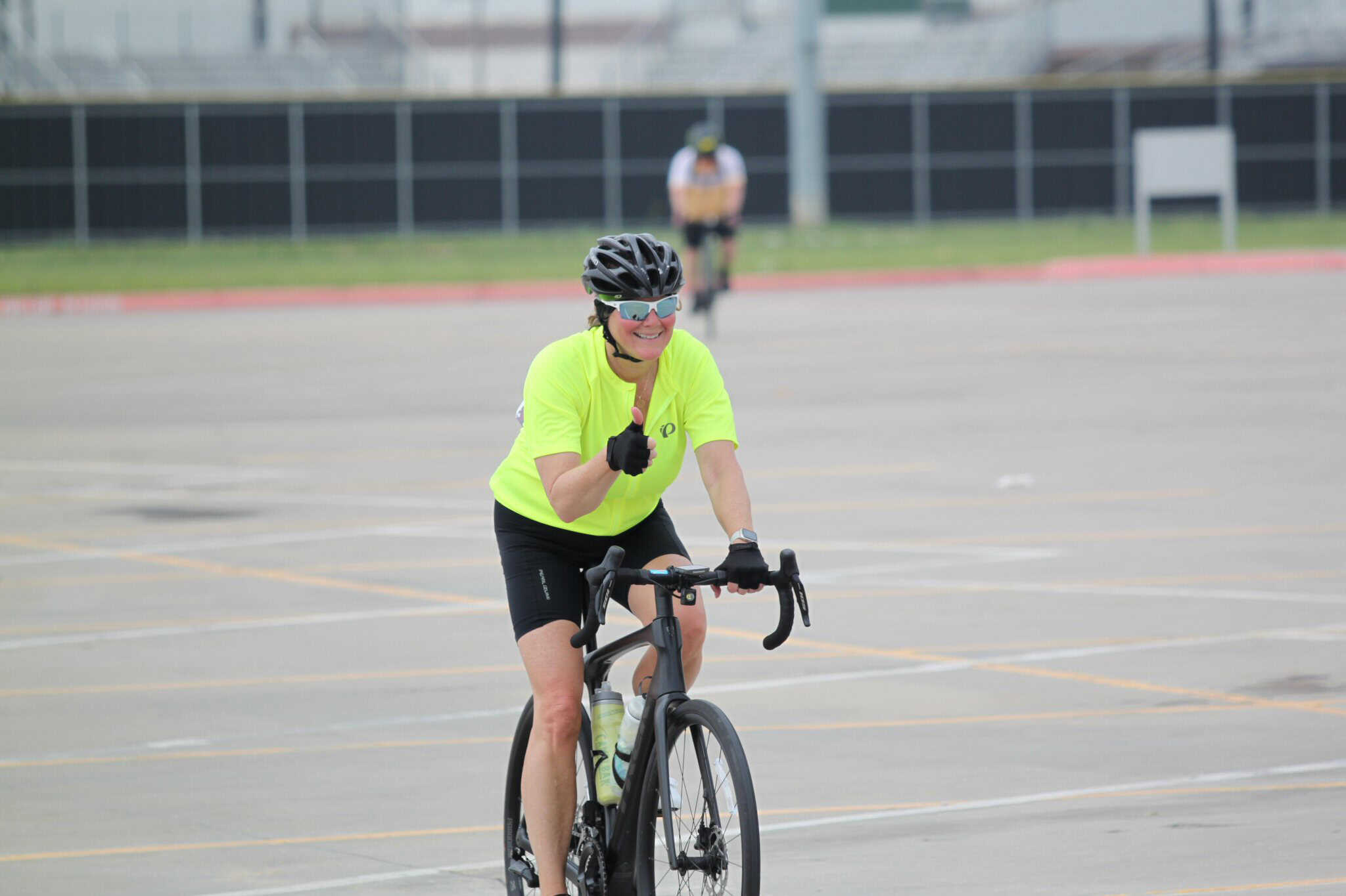 Vibrant cyclist in neon yellow shirt enjoying Bluebonnet Express ride during daytime.
