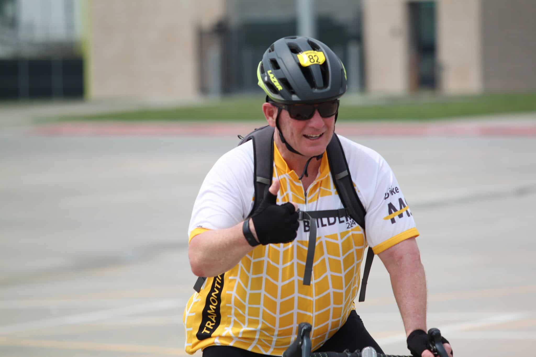 Cyclist giving thumbs up during Bluebonnet Express bike event on a sunny day.