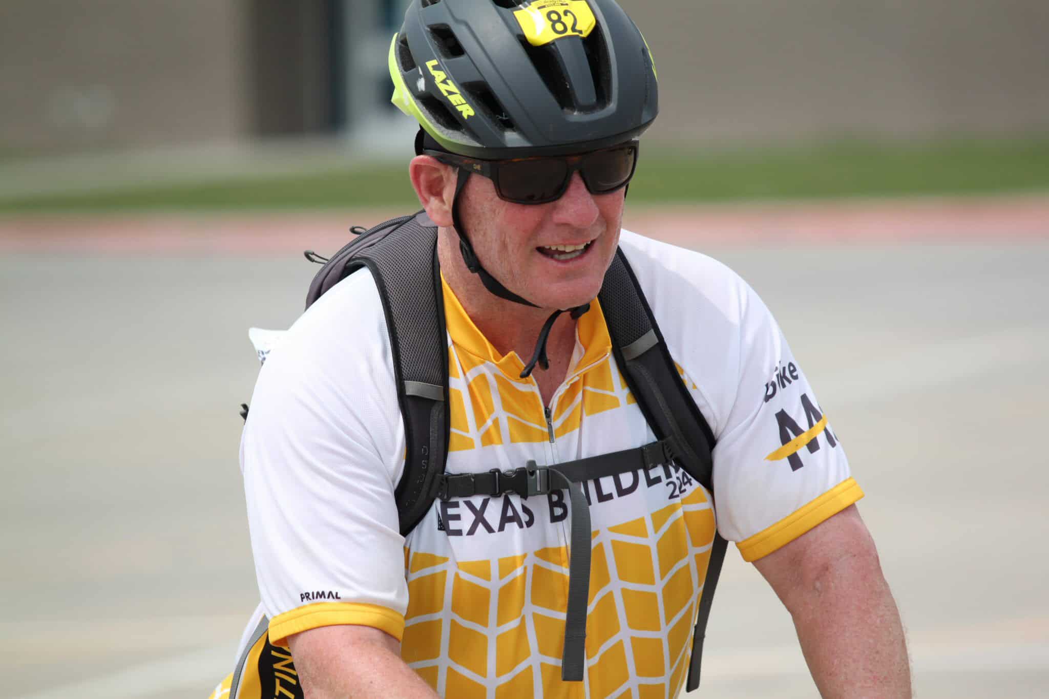 Rider wearing helmet and sunglasses at Bluebonnet Express cycling event, smiling during outdoor bike race.