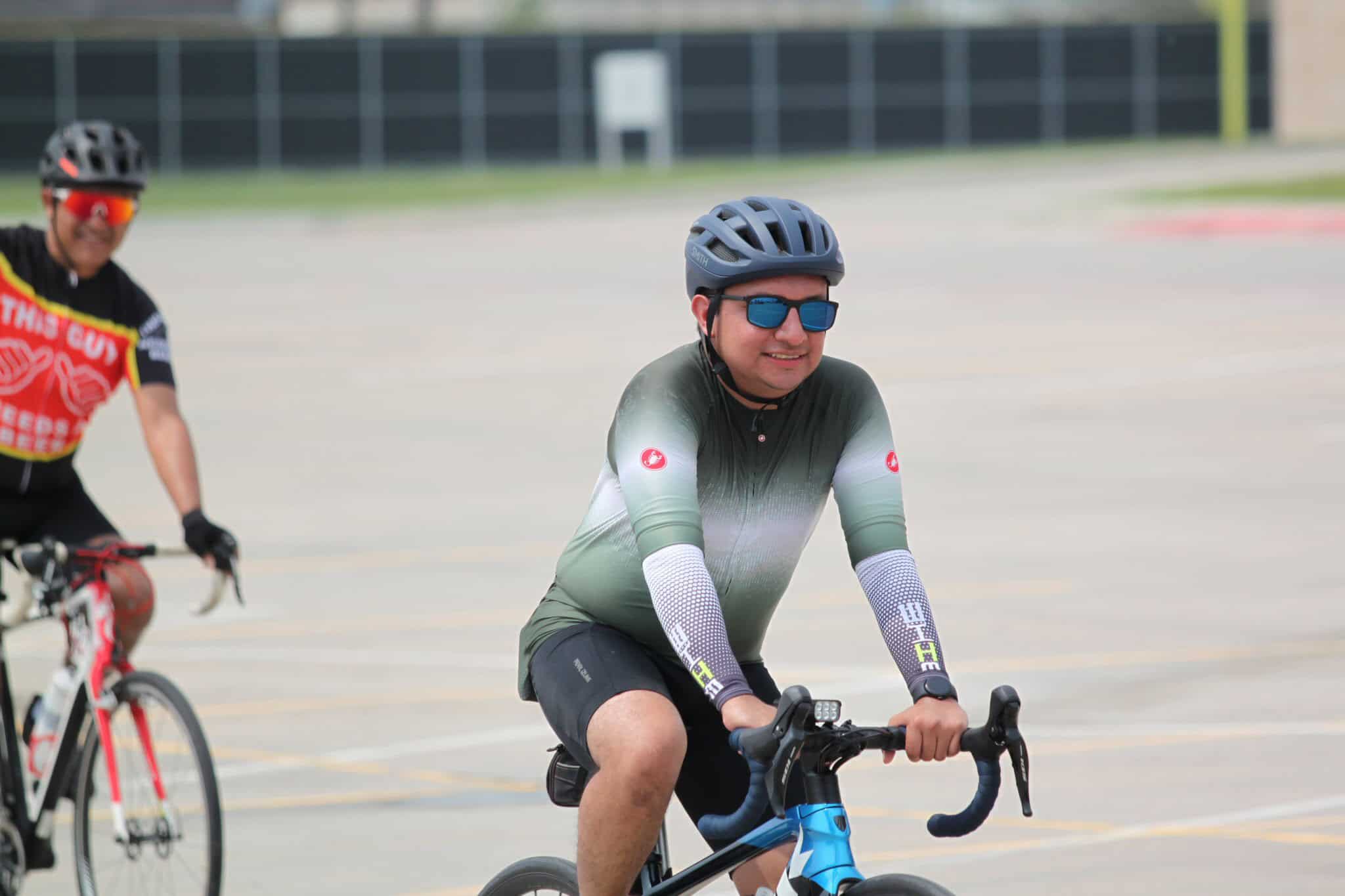 Bright smiling cyclist wearing sunglasses and helmet during Bluebonnet Express bike event.