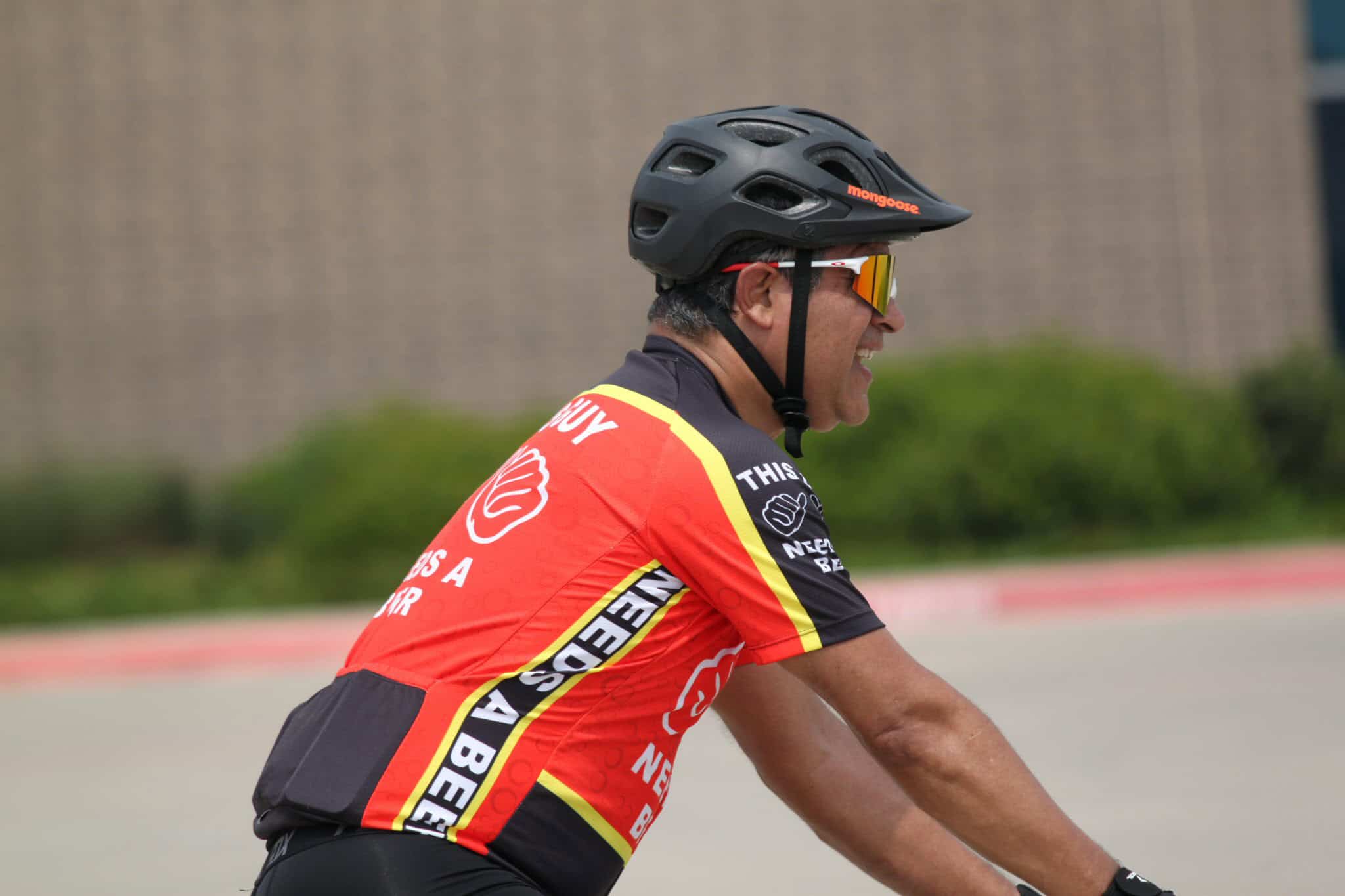 Helmeted cyclist enjoying a ride on a sunny day, promoting Bluebonnet Express bike services.