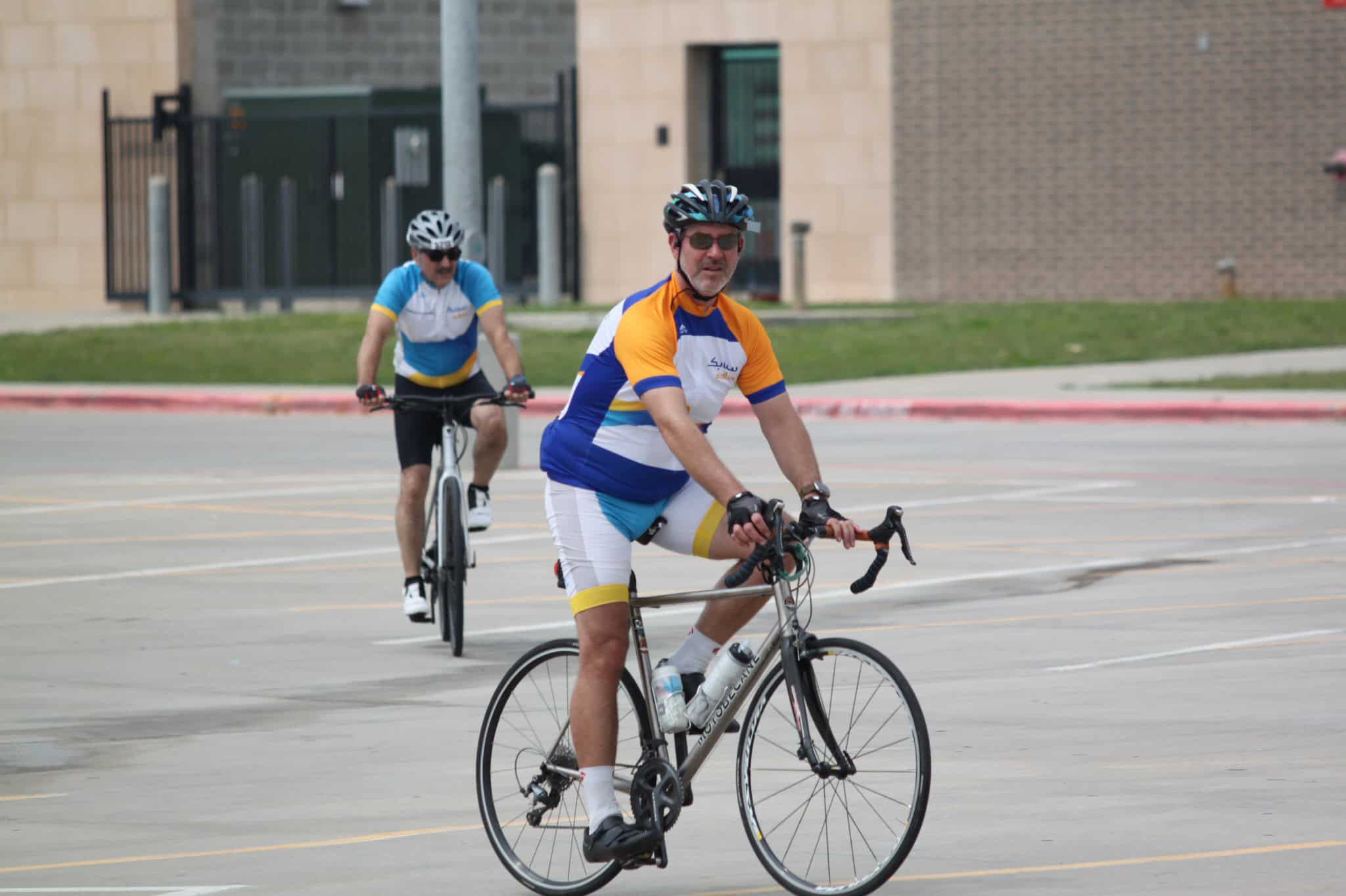 Brightly dressed cyclists enjoying a ride on a city street, showcasing Bluebonnet Express bike services.