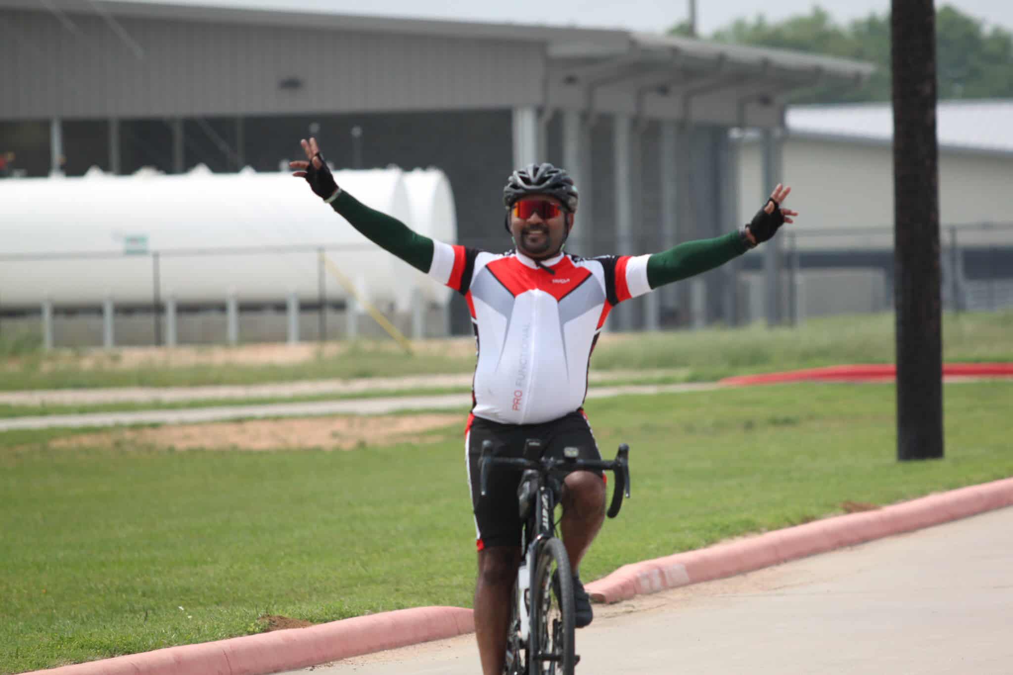 Vibrant cyclist celebrating victory on Bluebonnet Express bike trail outdoor in Texas.