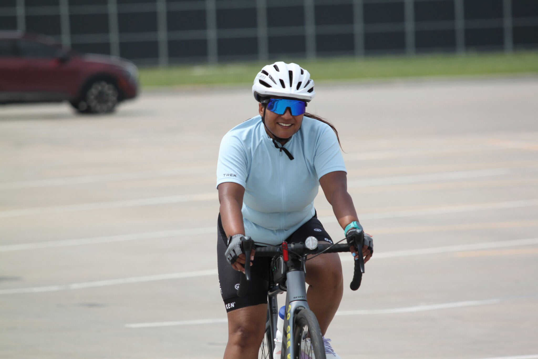 Comfortable woman cyclist riding a bike during daytime in a parking lot.