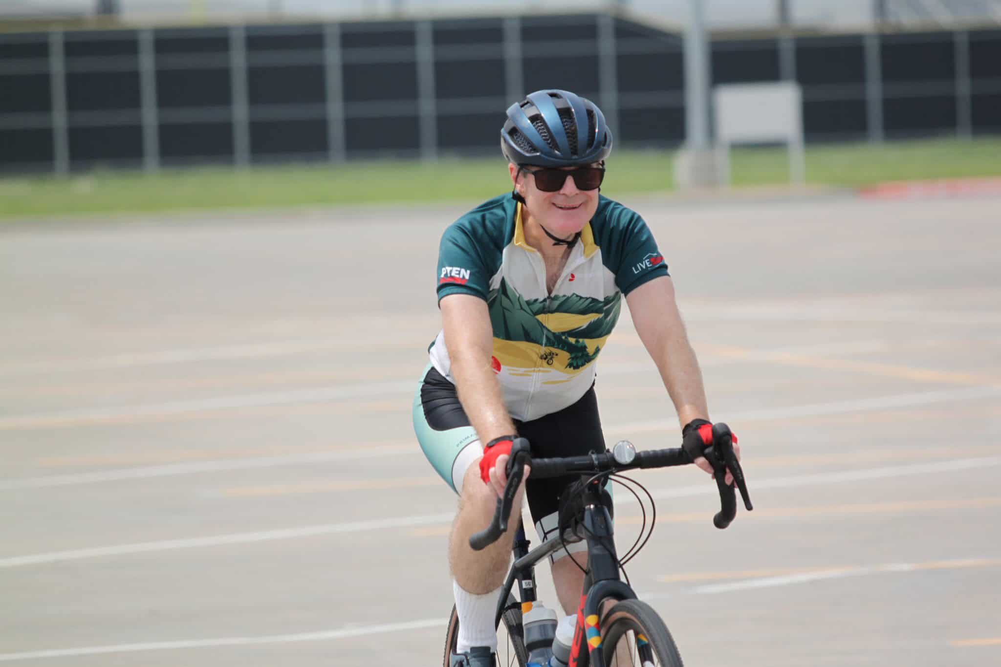 Bright cyclist riding along an outdoor track, showcasing Bluebonnet Express bike service for active transportation.