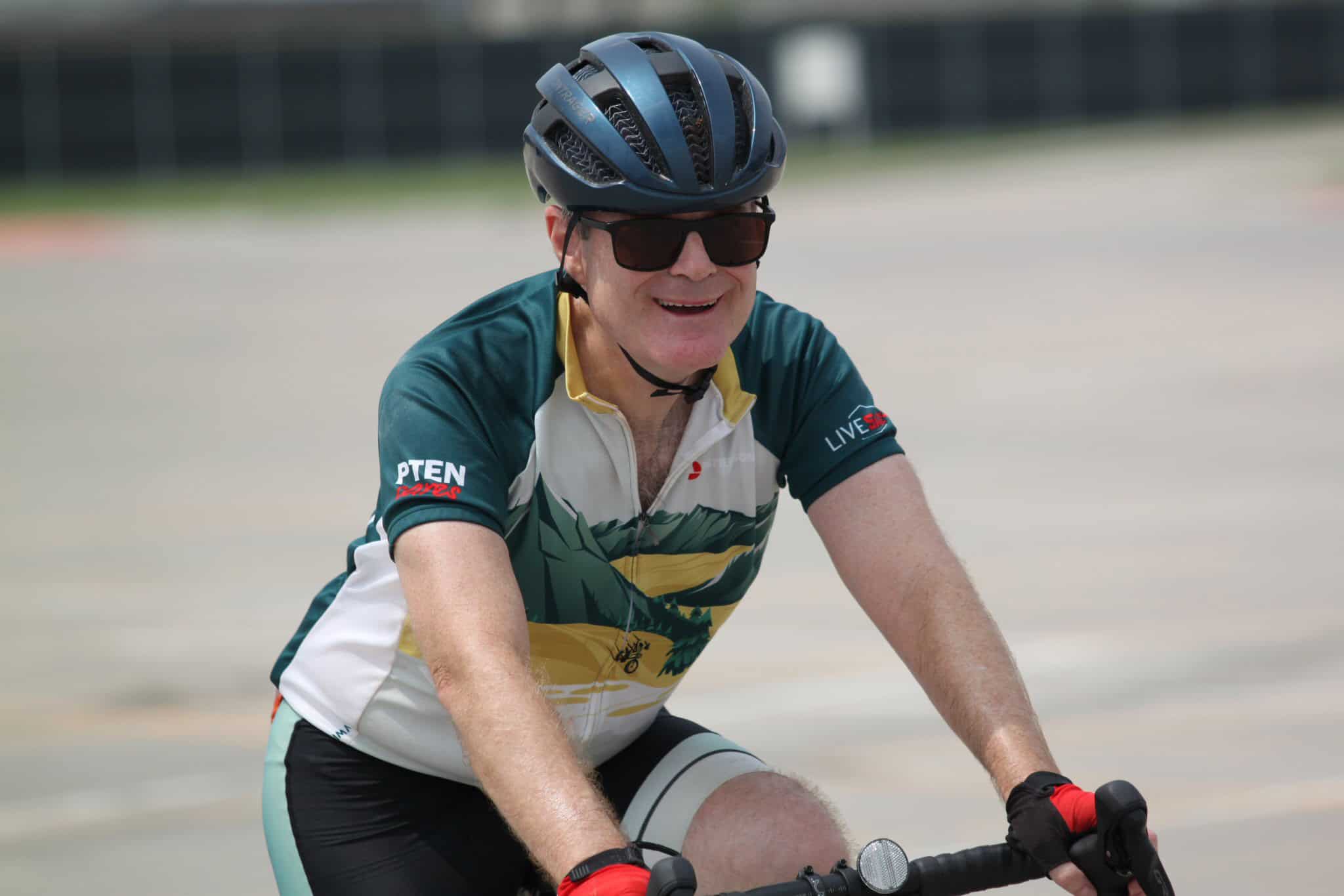 Vibrant cyclist in helmet and sunglasses enjoying a ride at Bluebonnet Express event.