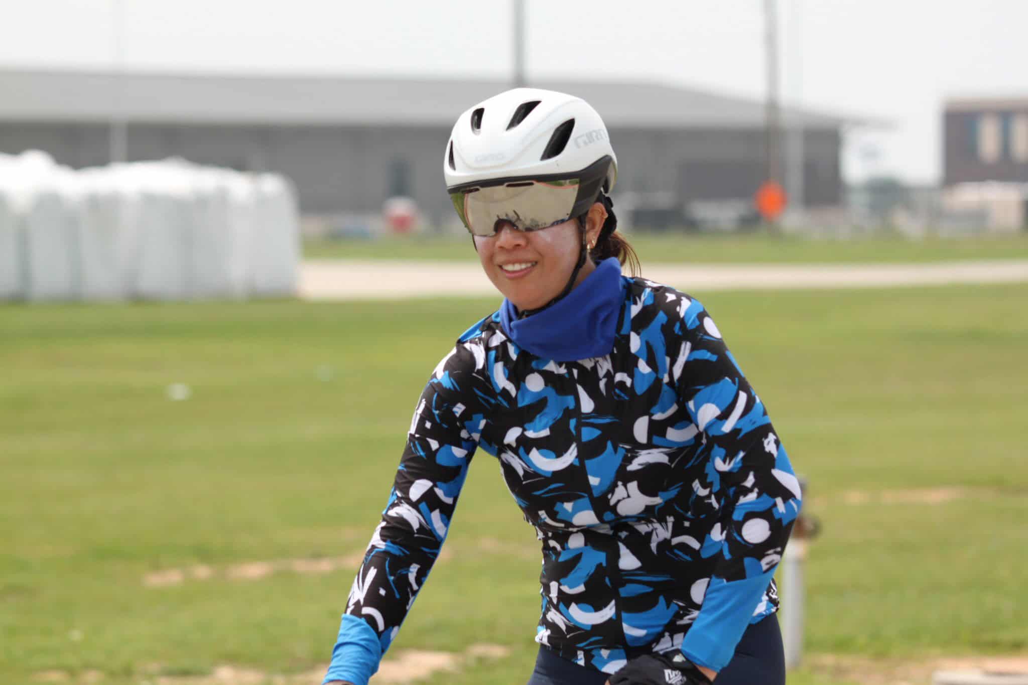 Bright female cyclist wearing a helmet and sunglasses at Bluebonnet Express bike event.