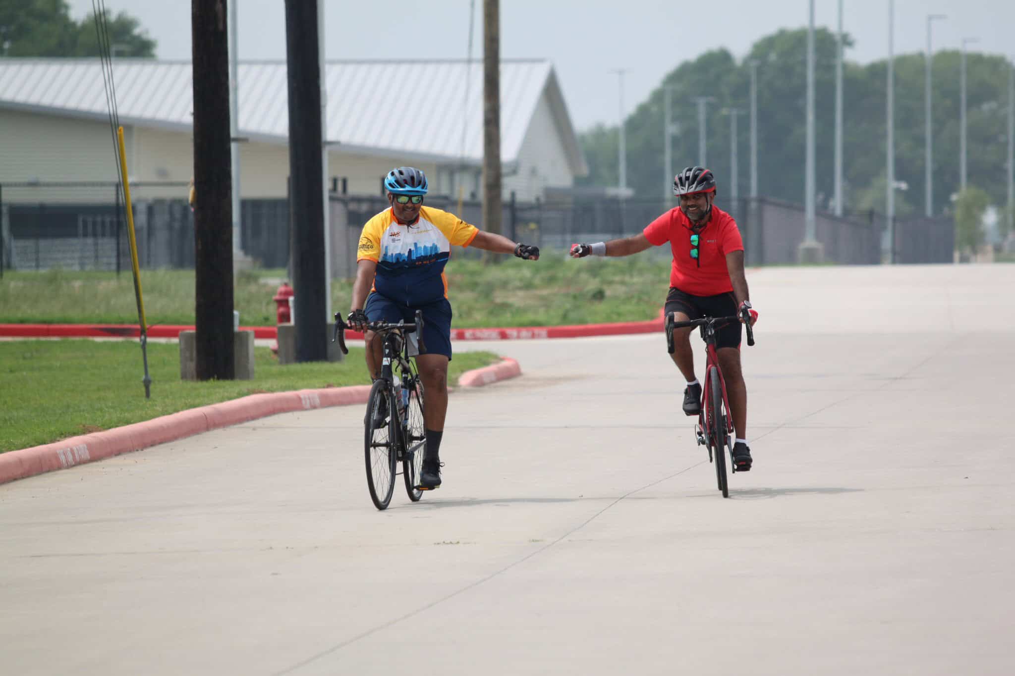 Brightly colored cyclists enjoying a ride on a paved road, showcasing Bluebonnet Express bike services.