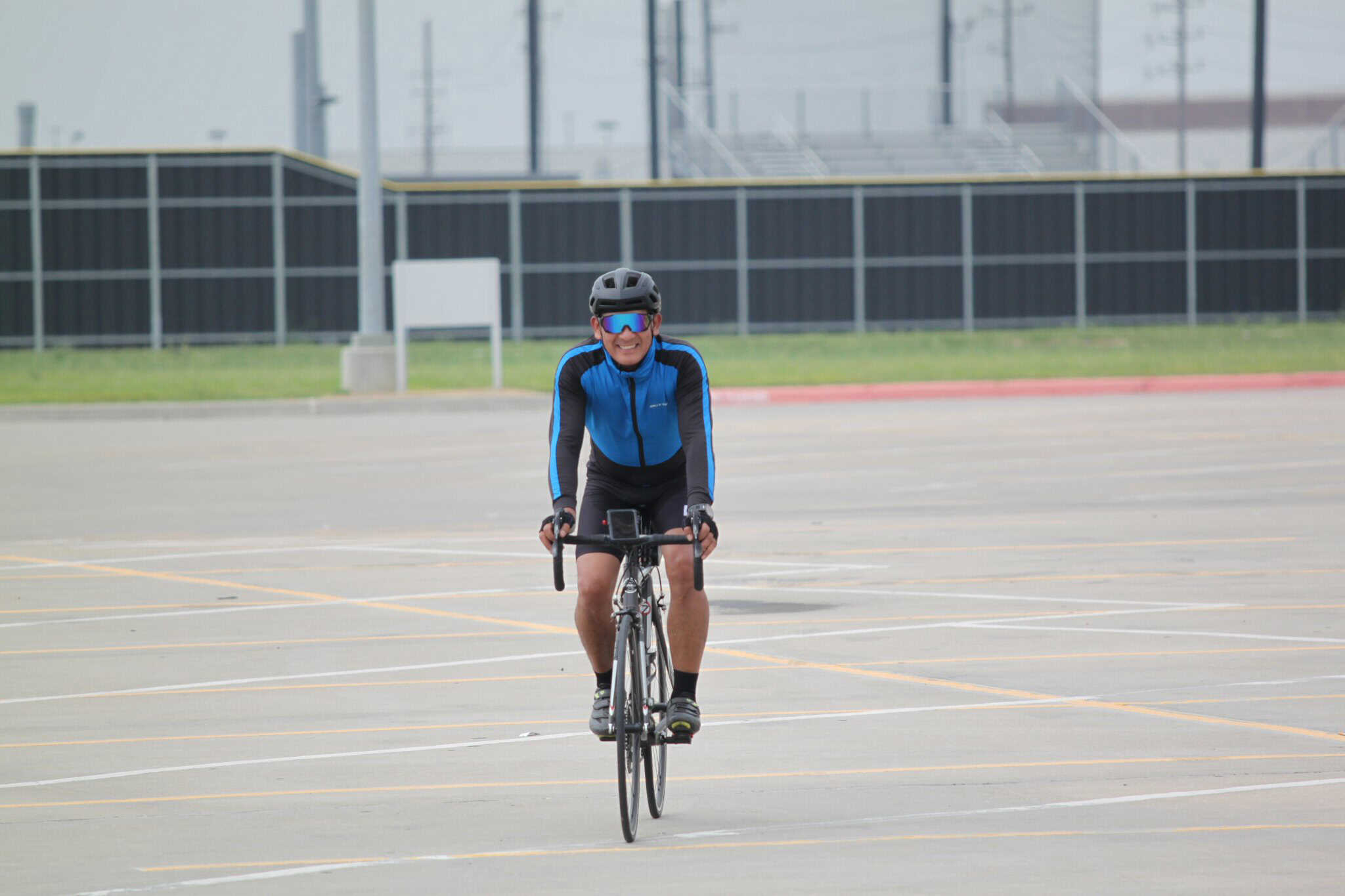 Vast bike parking lot with cyclist riding on a clear day, promoting Bluebonnet Express bike services.