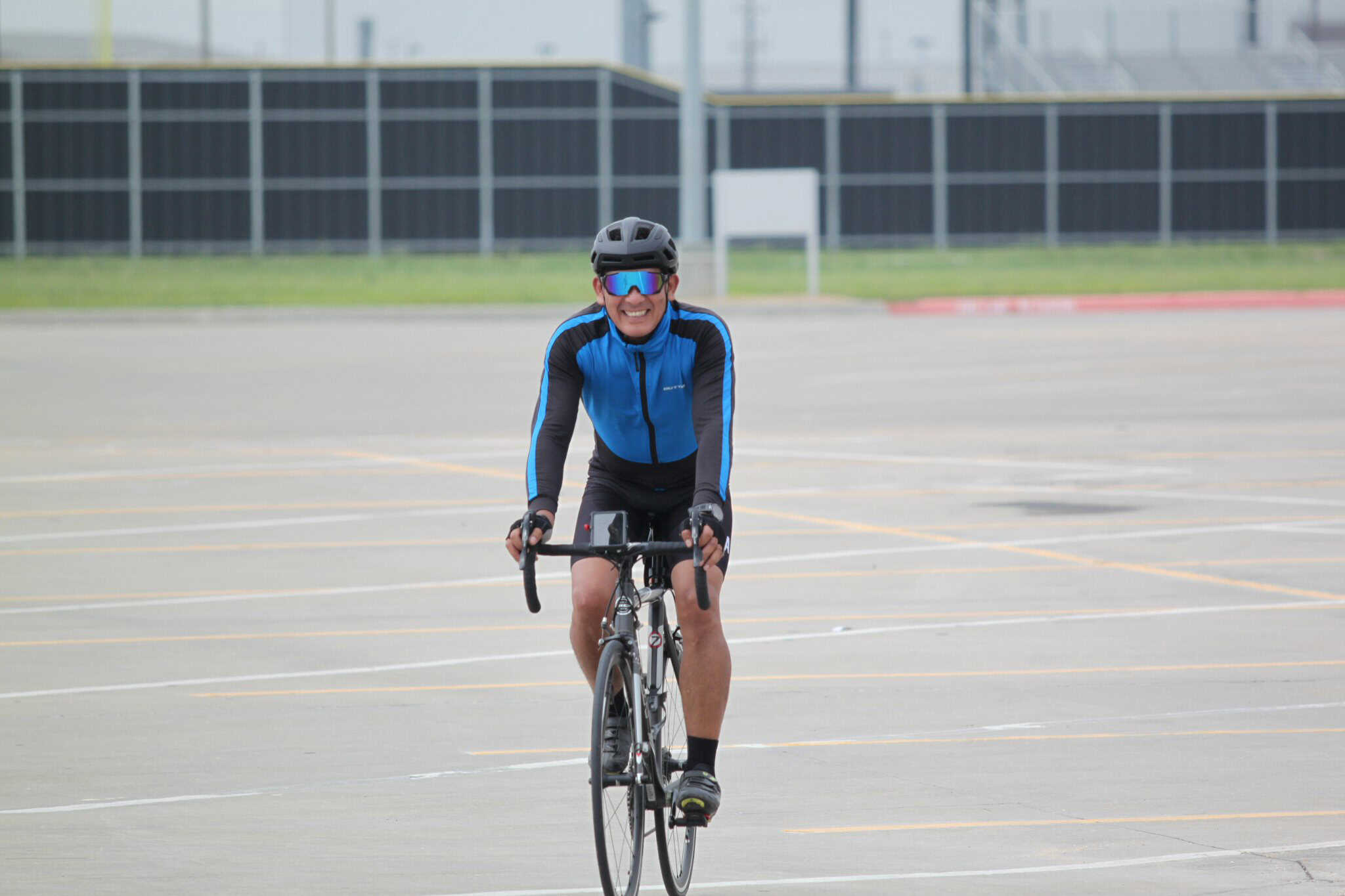 Bright cyclist riding on an empty parking lot, promoting Bluebonnet Express bike service.