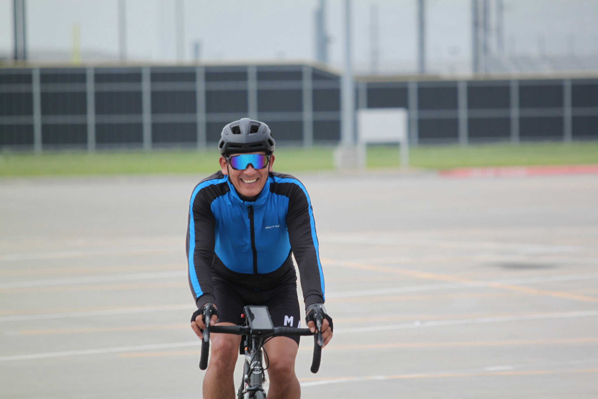 Vibrant cyclist riding blue bike in sunny outdoor setting, promoting Bluebonnet Express bike services.