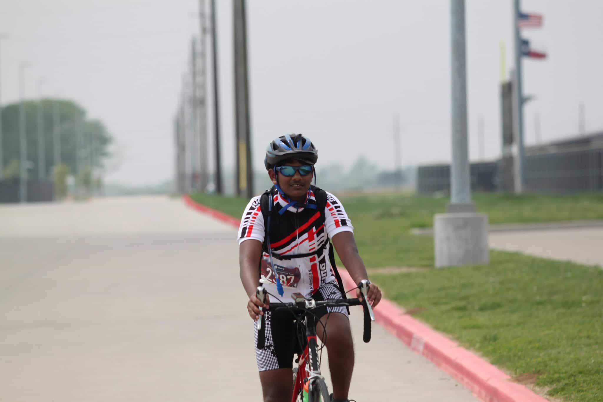Vibrant cyclist riding bike on the road during Bluebonnet Express event, showcasing cycling race in Texas.