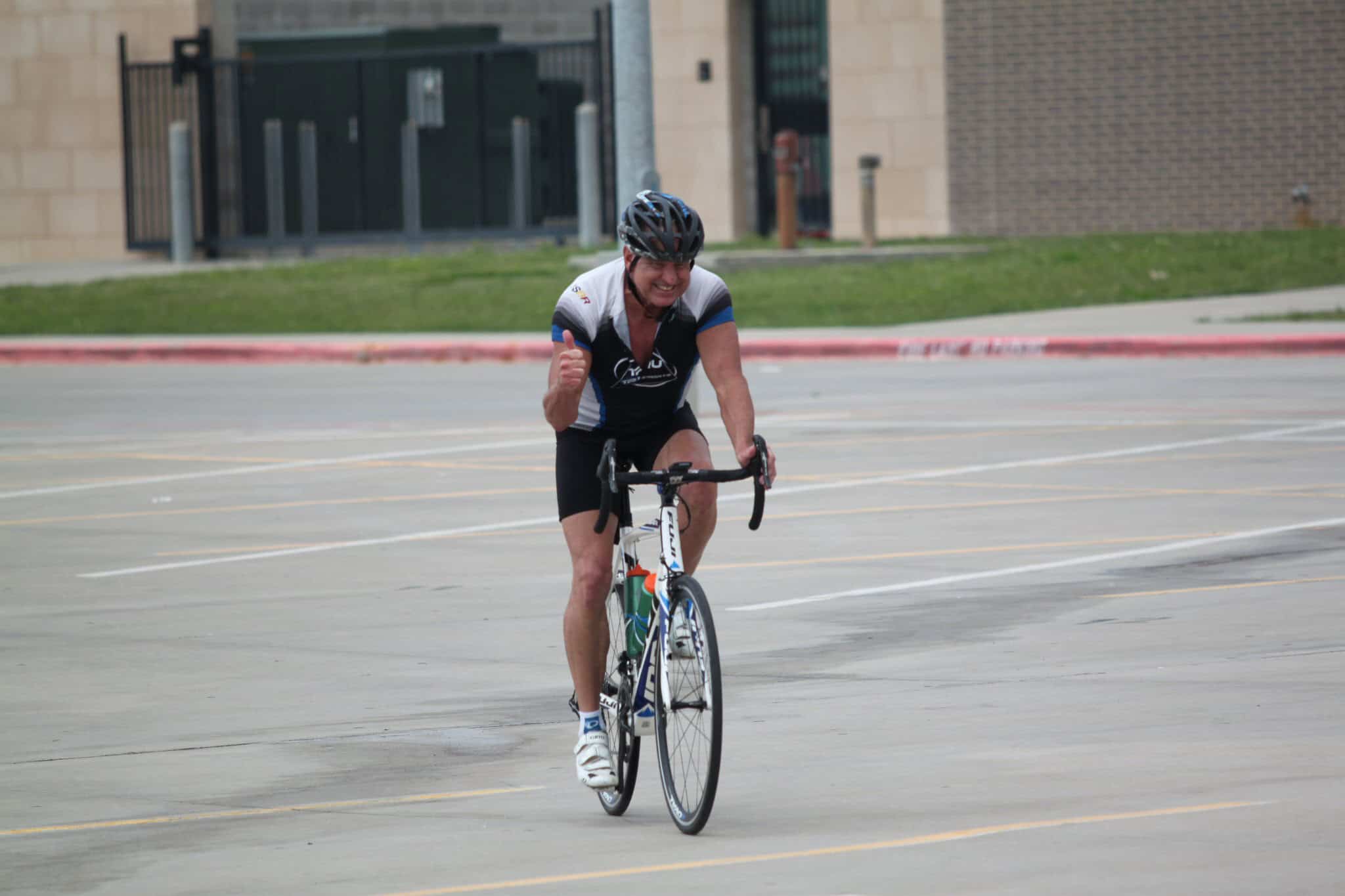 Energetic cyclist crossing finish line, celebrating victory on a cycling event.
