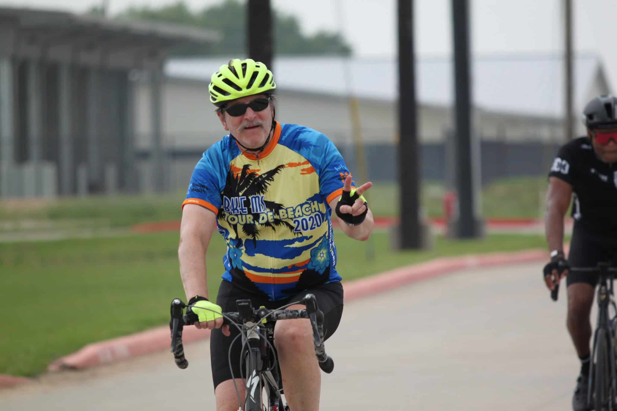 Bicycle rider wearing Bluebonnet Express team jersey cycling outdoors.